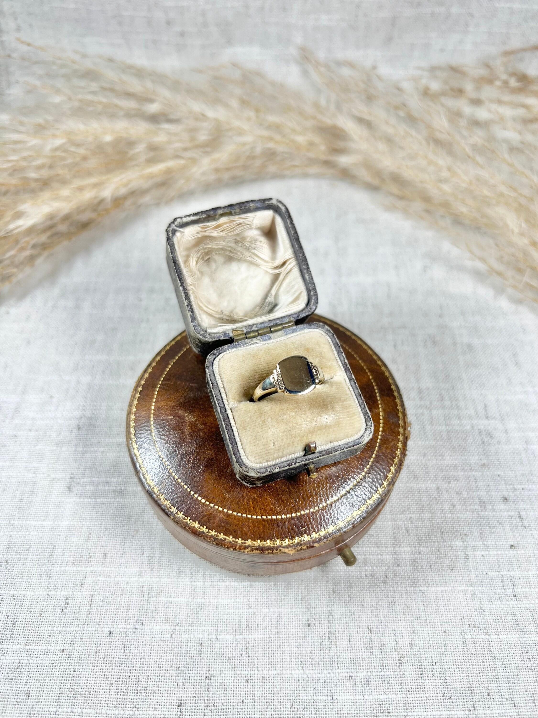 Vintage Signet Ring 

9ct Gold 

Hallmarked Birmingham 1955

Makers Mark C G & S

This vintage 9ct gold signet ring features a rounded square shape with a clean and plain surface, making it a timeless and versatile piece of jewellery. The ring is