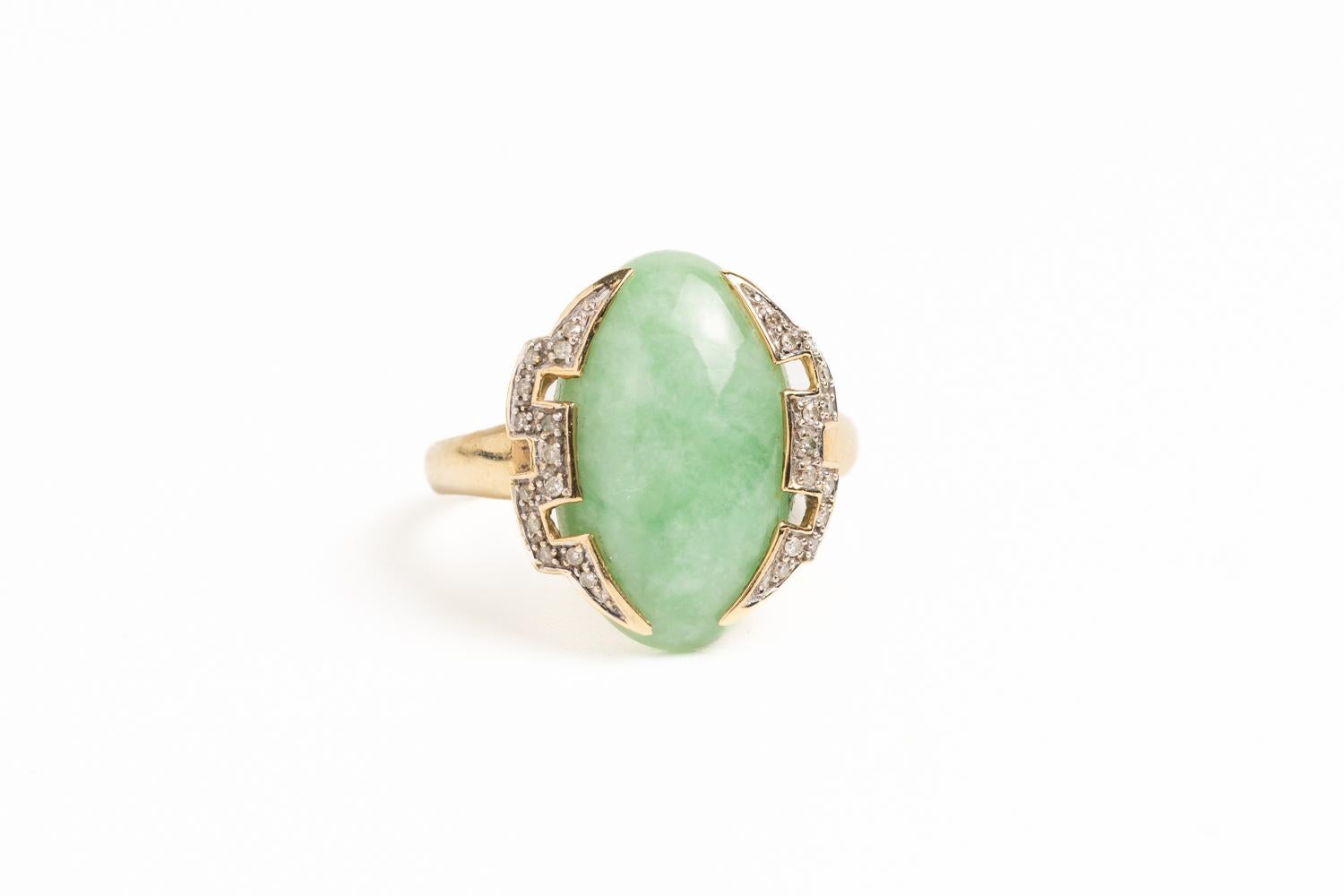 An elegant and gorgeous 9ct gold jade and diamond cocktail ring made in Art Deco style, comprising of a beautiful oval light green cabochon stone measuring approx. 22mm X 12mm. 

The central jade stone is surrounded by sparking diamonds in a