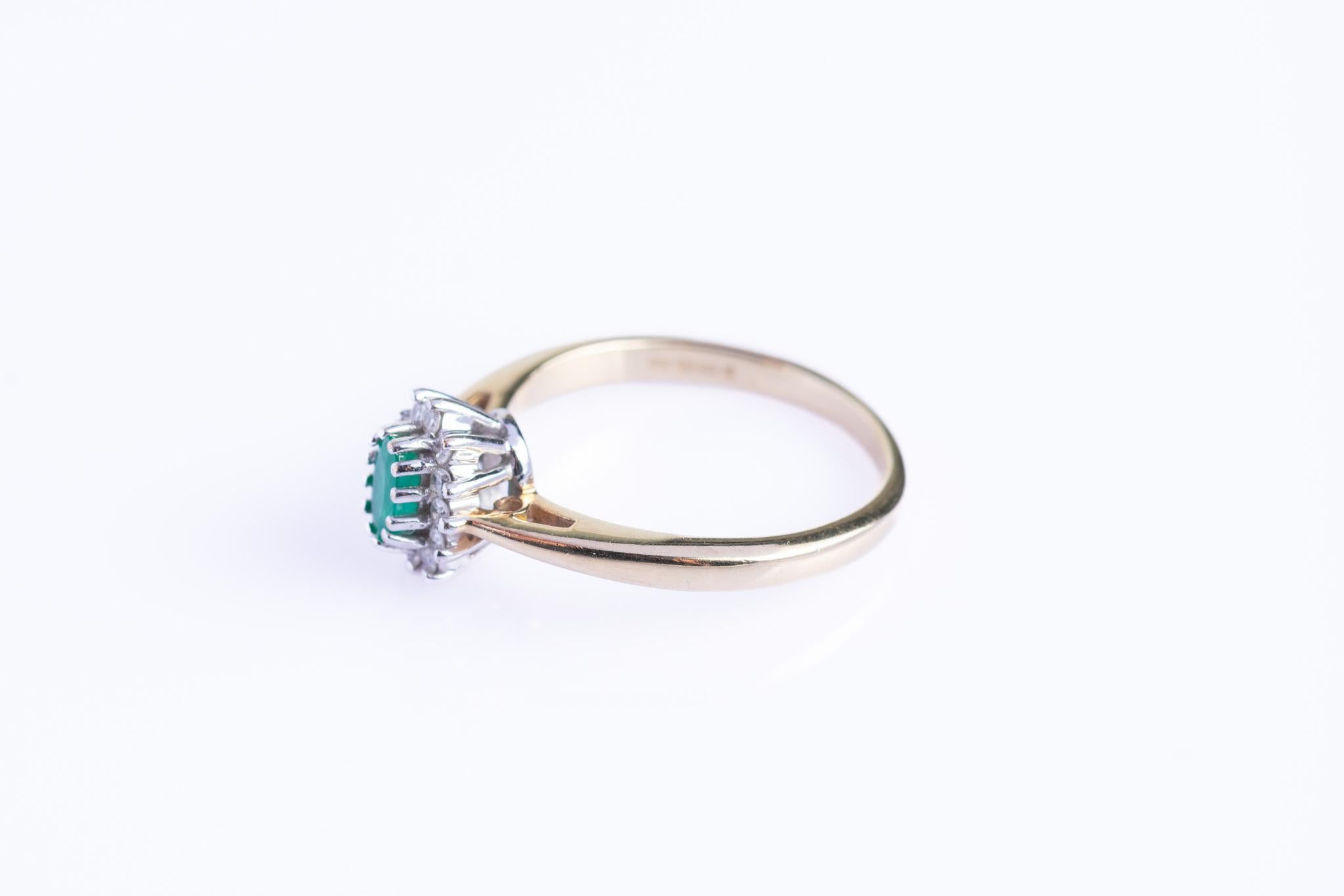 A beautiful vintage 9ct gold emerald cluster ring, framed by a halo of brilliant-cut diamonds. The warm tones of 9ct yellow gold enhance the fresh green of the emerald and the sparkle of the diamonds, giving the piece a refined and timeless