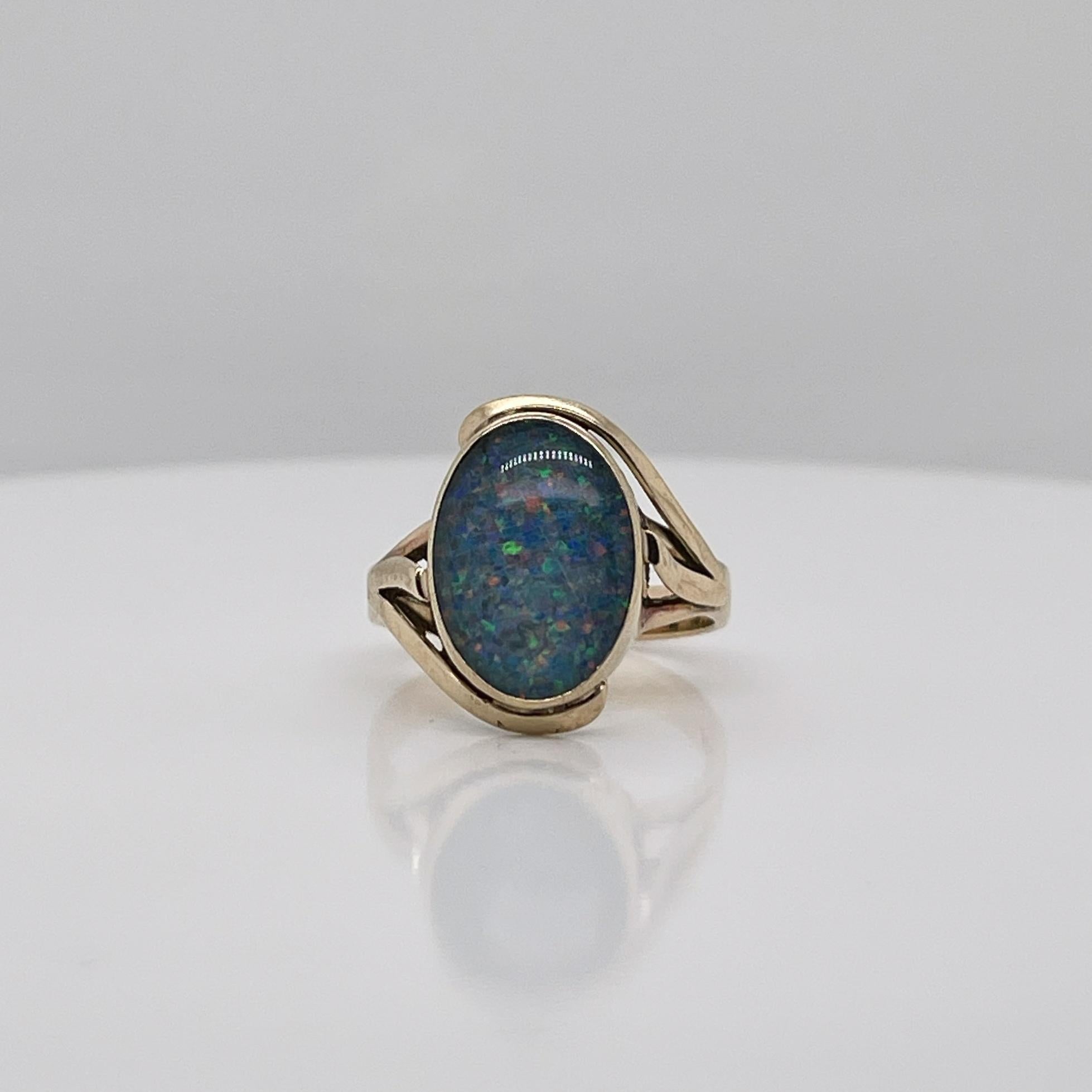 A very fine vintage gold and opal signet style ring.

With oval opal doublet cabochon bezel set in 9ct gold. 

Simply a great ring!

Date:
20th Century

Overall Condition:
It is in overall good, as-pictured, used estate condition with some very fine