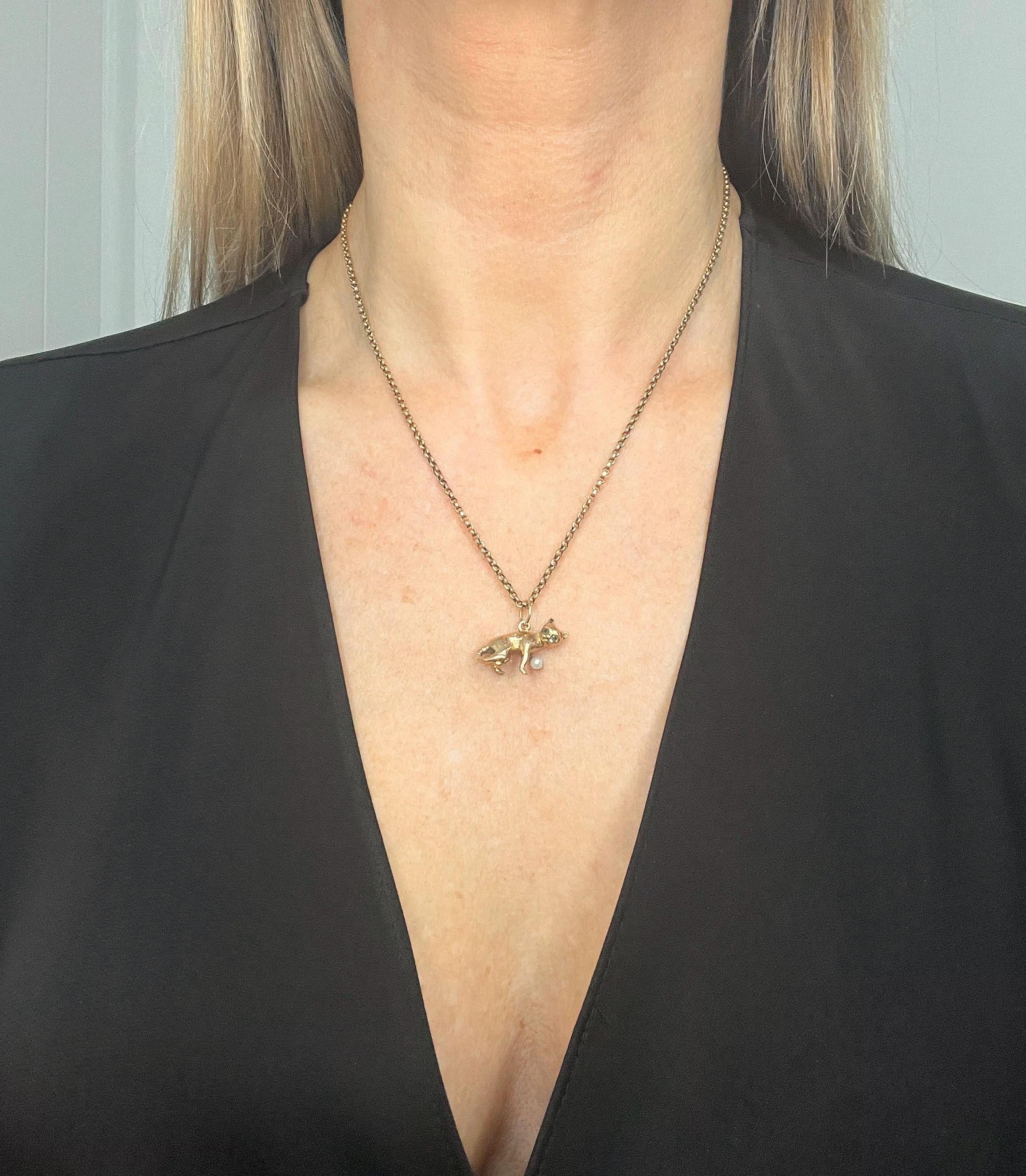 Vintage Cat Pendant

9ct Gold Stamped 375

Hallmarked Birmingham 1978

Makers Mark A J H 

Introducing our charming solid 9ct yellow gold vintage cat pendant with green-coloured stone eyes and a natural seed pearl in his paw. This delightful feline