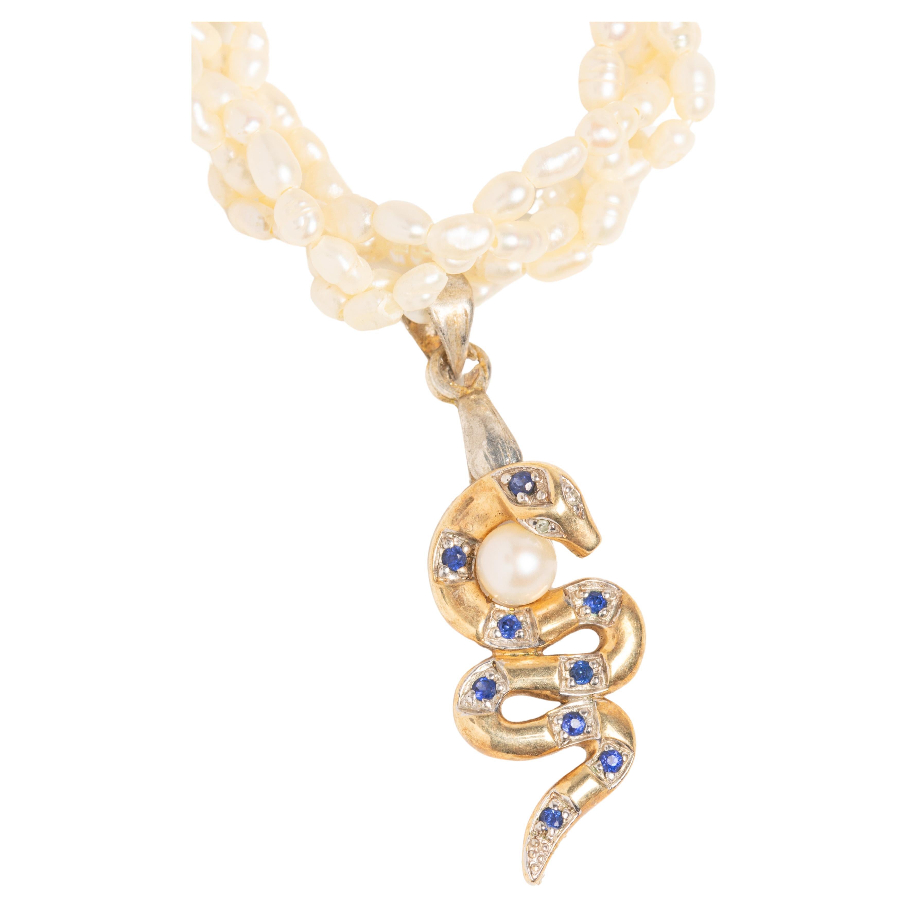 Gorgeous and elegant 9ct gold pearl necklace with snake suspended set with sapphires and diamonds. This vintage rice pearl four-strand necklace/choker is decorated with a 9ct gold serpent sapphire and diamond snake pendant holding a pearl under his