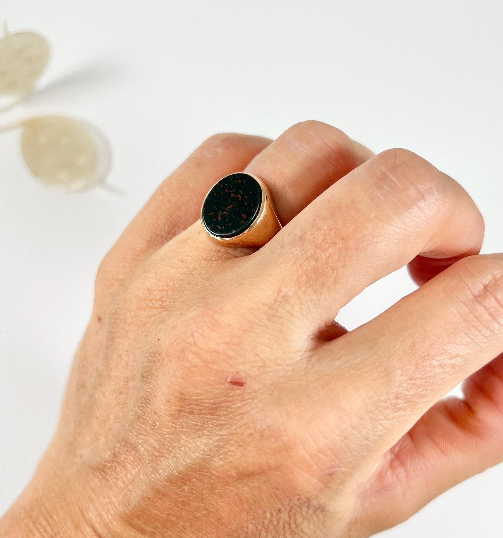 Vintage Signet Ring 

9ct Gold 

Hallmarked London 1956

Makers Mark  W W Ld

This vintage signet ring is crafted from 9ct gold and features an oval bloodstone at its centre. The ring dates back to the 1950s and is hallmarked London 1956, with a