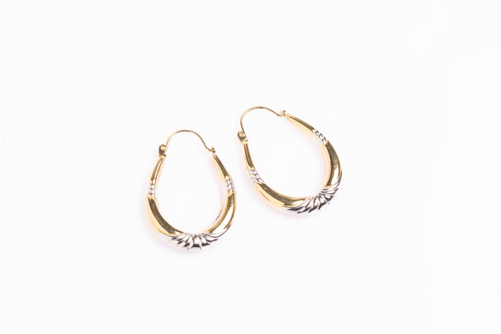 A gorgeous pair of vintage 9ct gold hoop earrings in an elegant tapered teardrop shape, beautifully finished with polished yellow gold and contrasting white gold accents. The ridged detailing adds a subtle Art Deco revival feel, while the sleek form