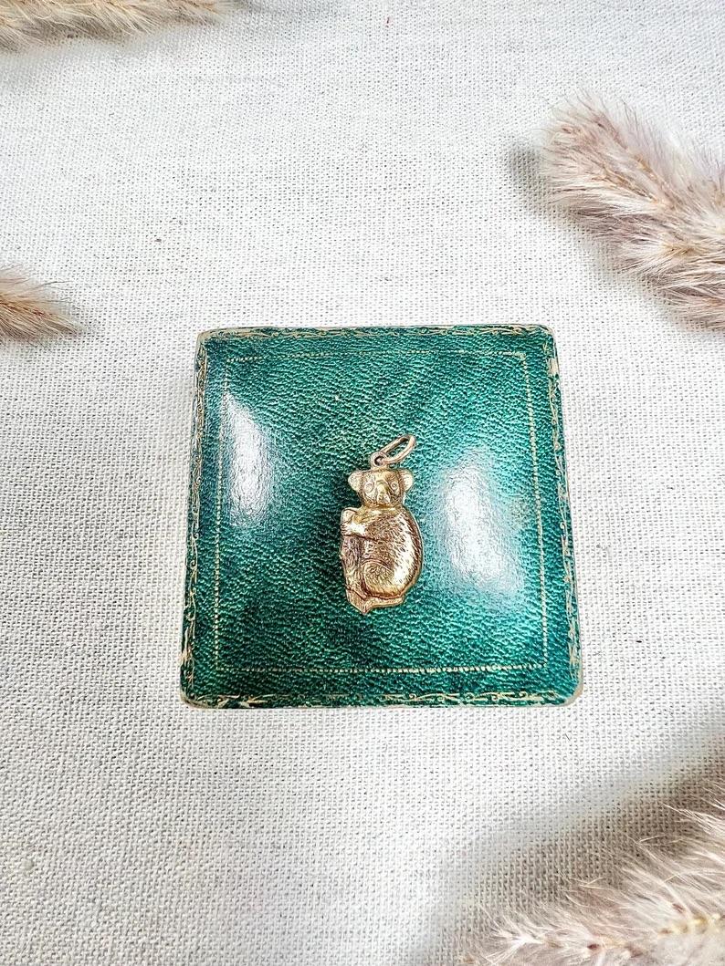 Vintage Koala Pendant

9ct Gold Stamped 

Hallmarked Birmingham 1969

Makers Mark W H C 

This charming 9ct gold hallmarked koala pendant/charm captures the playful nature of the beloved Australian marsupial. The koala is depicted hugging a bamboo,