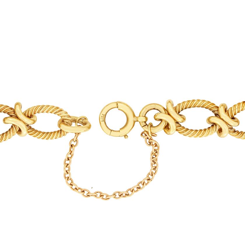 Avec des poinçons datant de 1963, ce bracelet à chaîne classique est fabriqué en or jaune 9 carats. Le bracelet ovale mesure 18 cm de long et 10,5 mm de large, ce qui le rend très facile à porter. Il est orné d'un motif texturé sur les parties