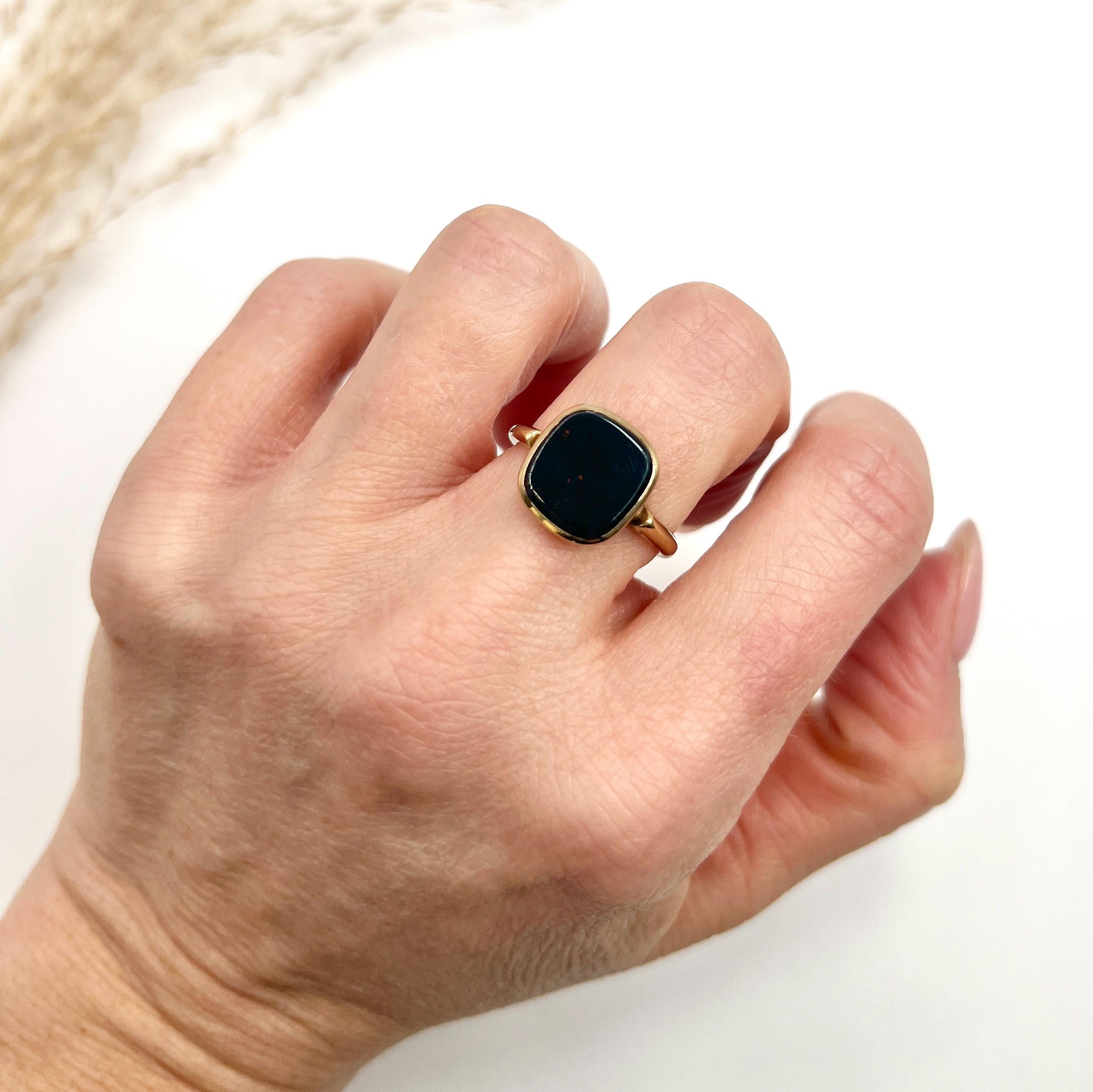 Vintage Signet Ring 

9ct Yellow Gold 

Hallmarked Chester- The date letter has rubbed

Circa 1940s

This vintage signet ring is crafted from 9ct yellow gold and features a rounded edge square-shaped bloodstone at its centre. The ring dates back to