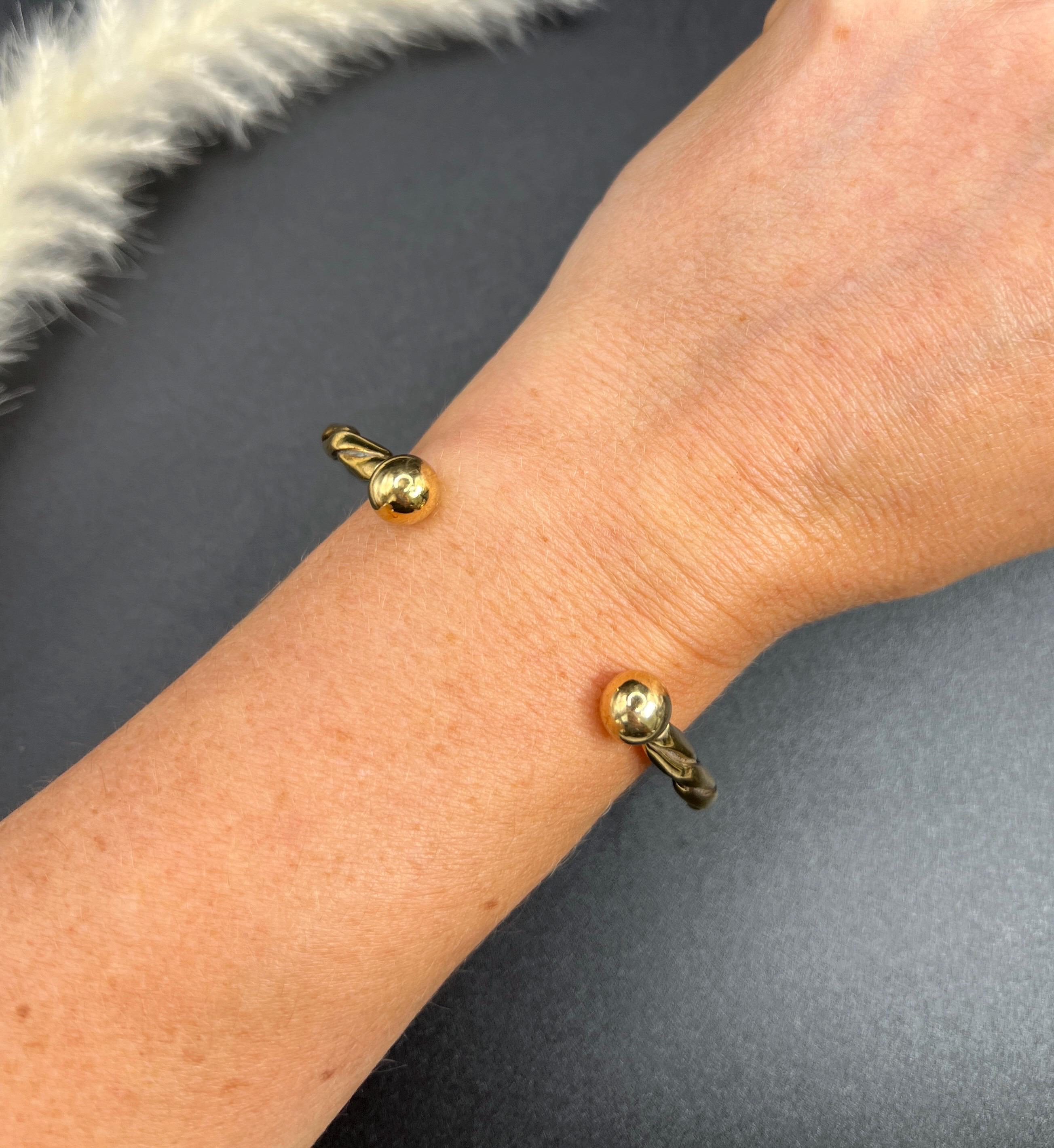 Vintage Torque Bangle 

9ct Gold Stamped 375

Embrace the elegance of the past with this stunning 1980s vintage gold torque bangle, crafted in a beautiful yellow gold that exudes warmth and sophistication. This eye-catching piece features an