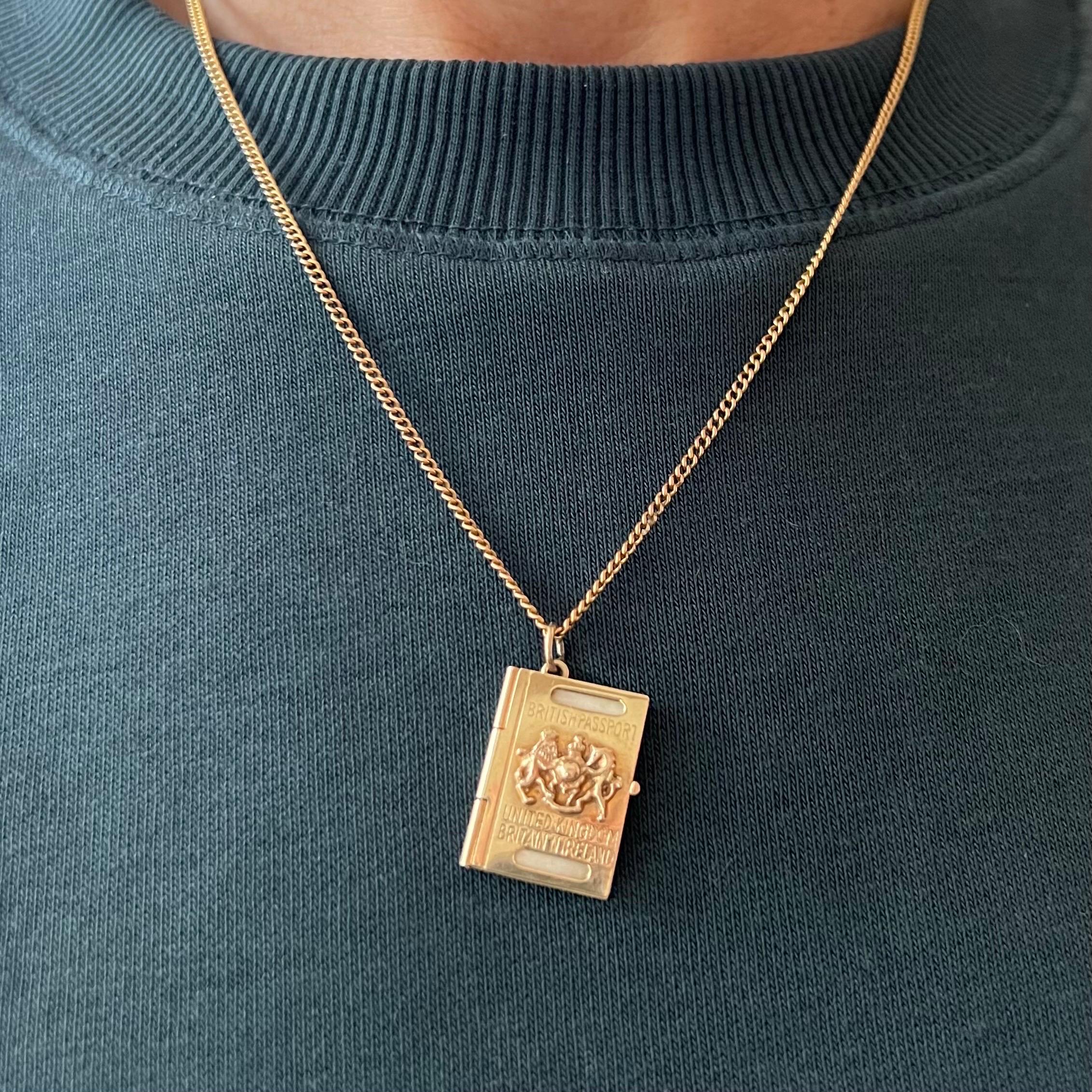 A vintage 9 karat yellow gold British Passport charm pendant. This miniature travel document is beautifully detailed with stamped papers on the inside. The gorgeous relief cover displays the British coat of arms depicting a lion and a unicorn