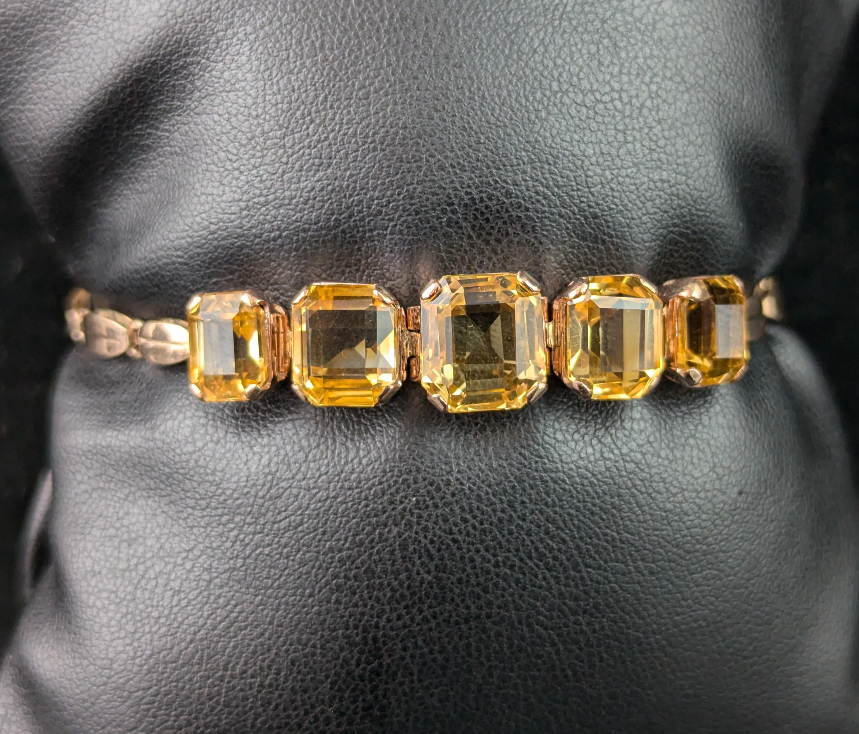 Ce magnifique bracelet vintage en or 9ct à la citrine est une pièce magnifique et édifiante.

En or 9ct avec un soupçon de rose, il présente un bracelet à maillons fantaisie, dont le devant est orné de cinq citrines taillées en escalier, riches et
