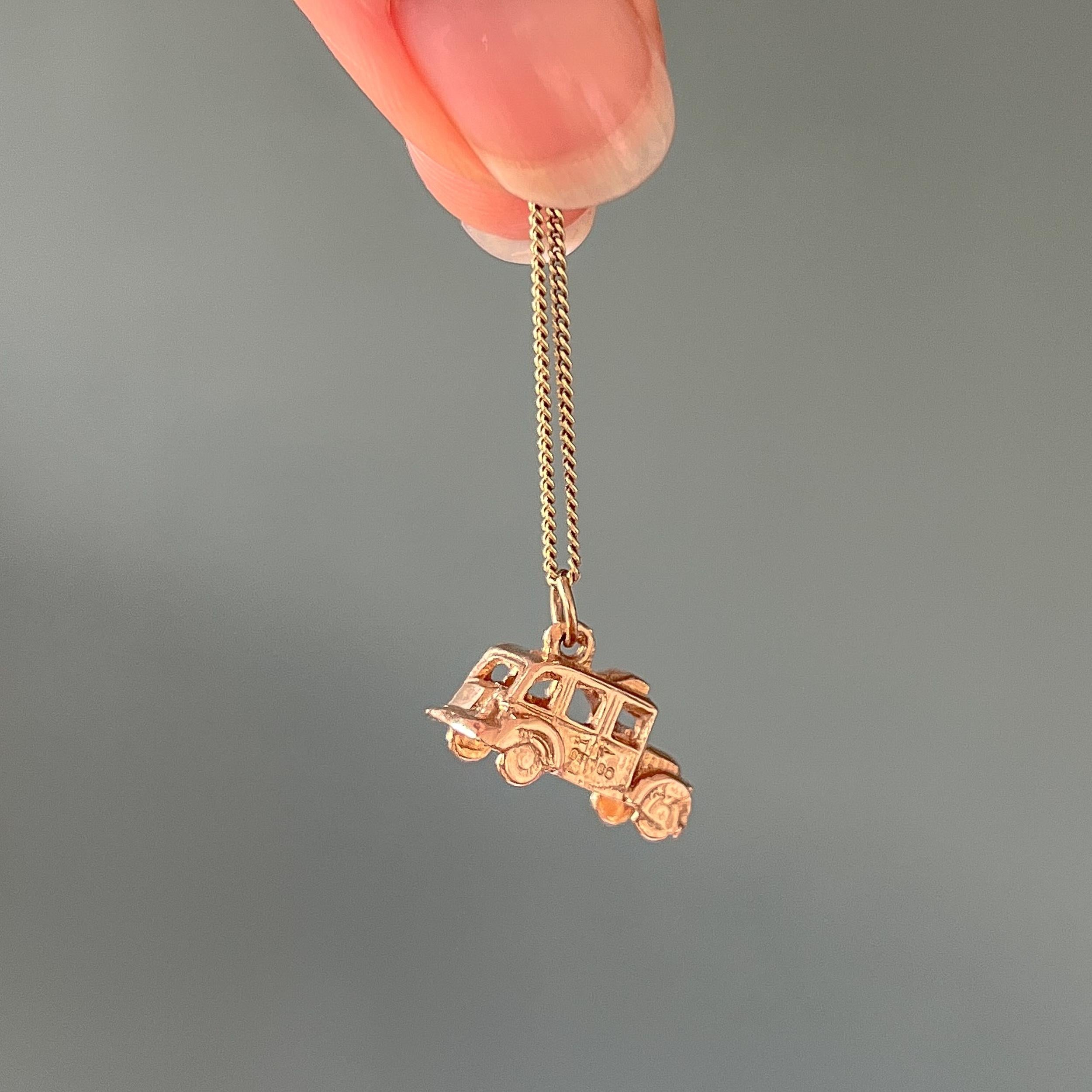 This is a vintage 9 karat yellow gold English taxi cab charm pendant. The charm is nicely detailed with the taxi sign on the roof and the grill in the front. It has open windows and door on the passengers seat. The bottom and inside is open and not