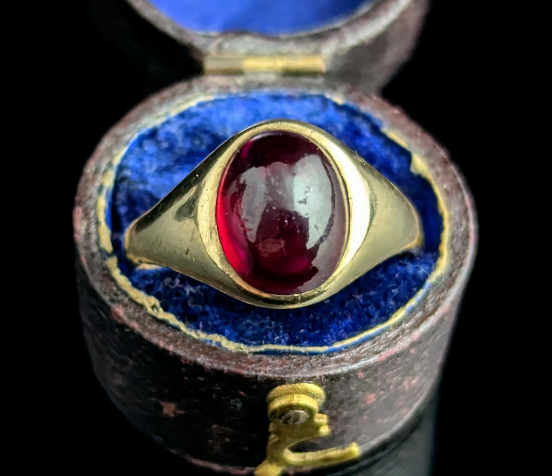 An interesting and handsome vintage Garnet signet ring.

It has a rich yellow gold mount with a single cabochon cut Garnet.

The ring has a smooth band and shoulders and the stone is bezel set into the mount.

The ring mount is older than the stone