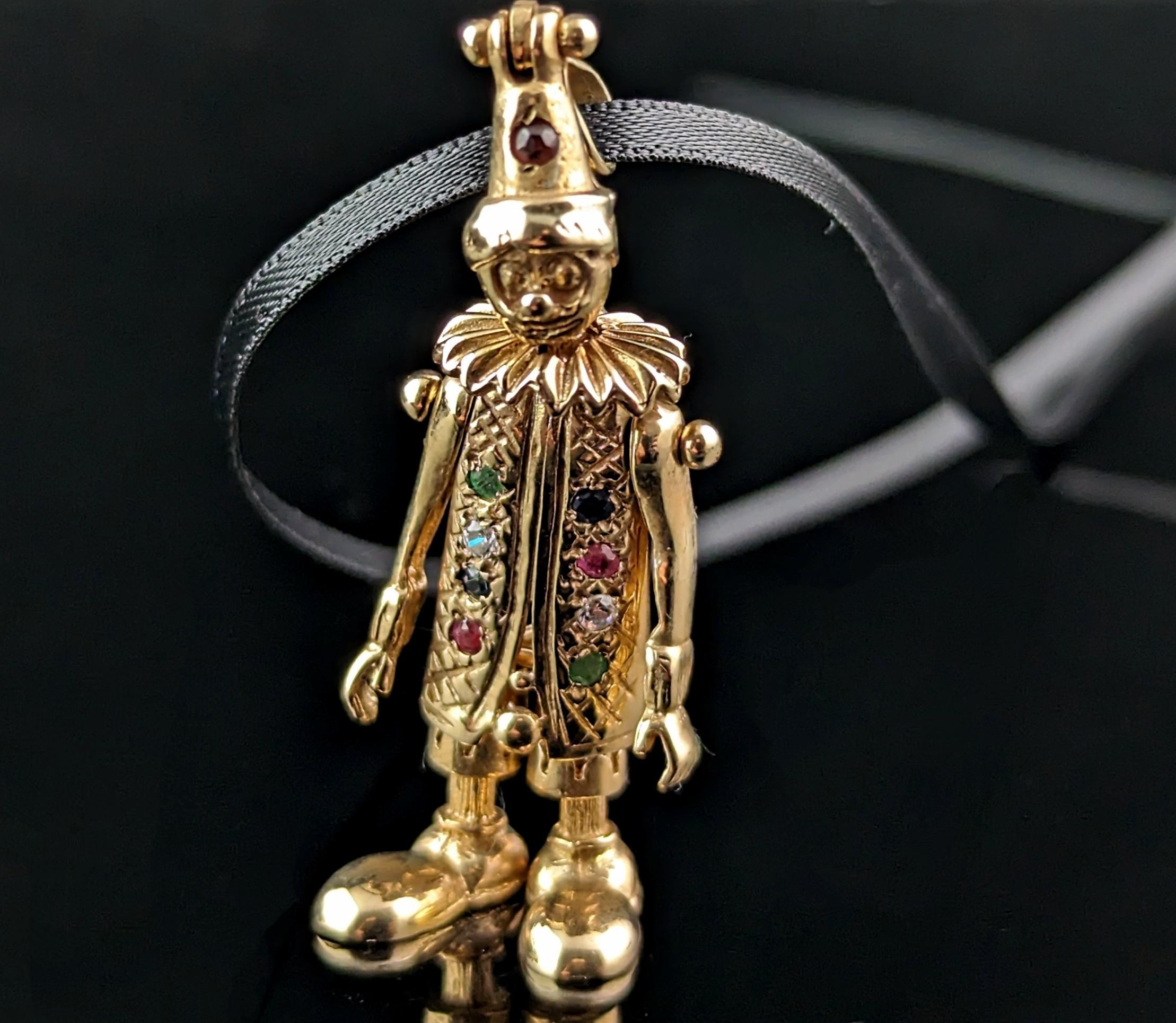 A fantastic vintage 9ct yellow gold articulated clown pendant.

A classic favourite from the 90s this clown pendant is fully articulated and has movable limbs.

It is set with clear paste, Sapphire, Garnet, Ruby and Emerald stones to the front, down