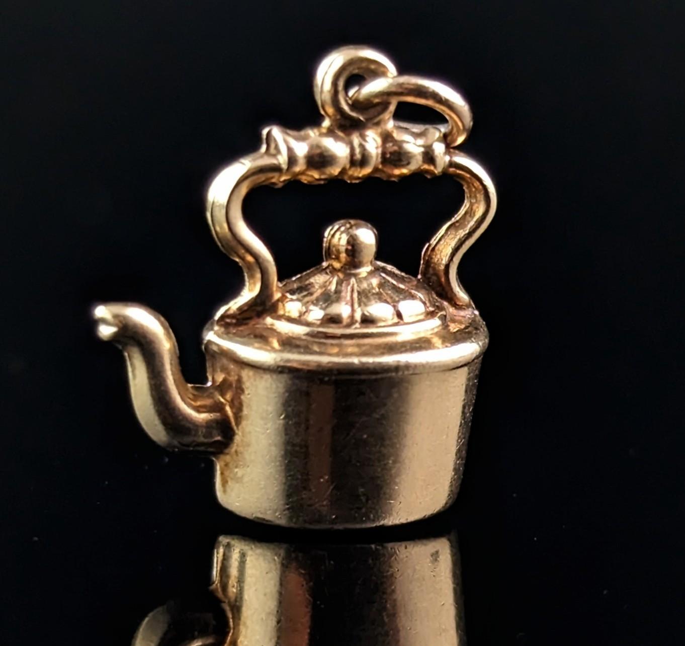 This little novelty vintage 9ct gold charm or pendant really has so much going on in such a small package.

It is finely modelled in rich 9ct yellow gold as a little Victorian style kettle, one that sits atop a stove.

The charm is a mid-century