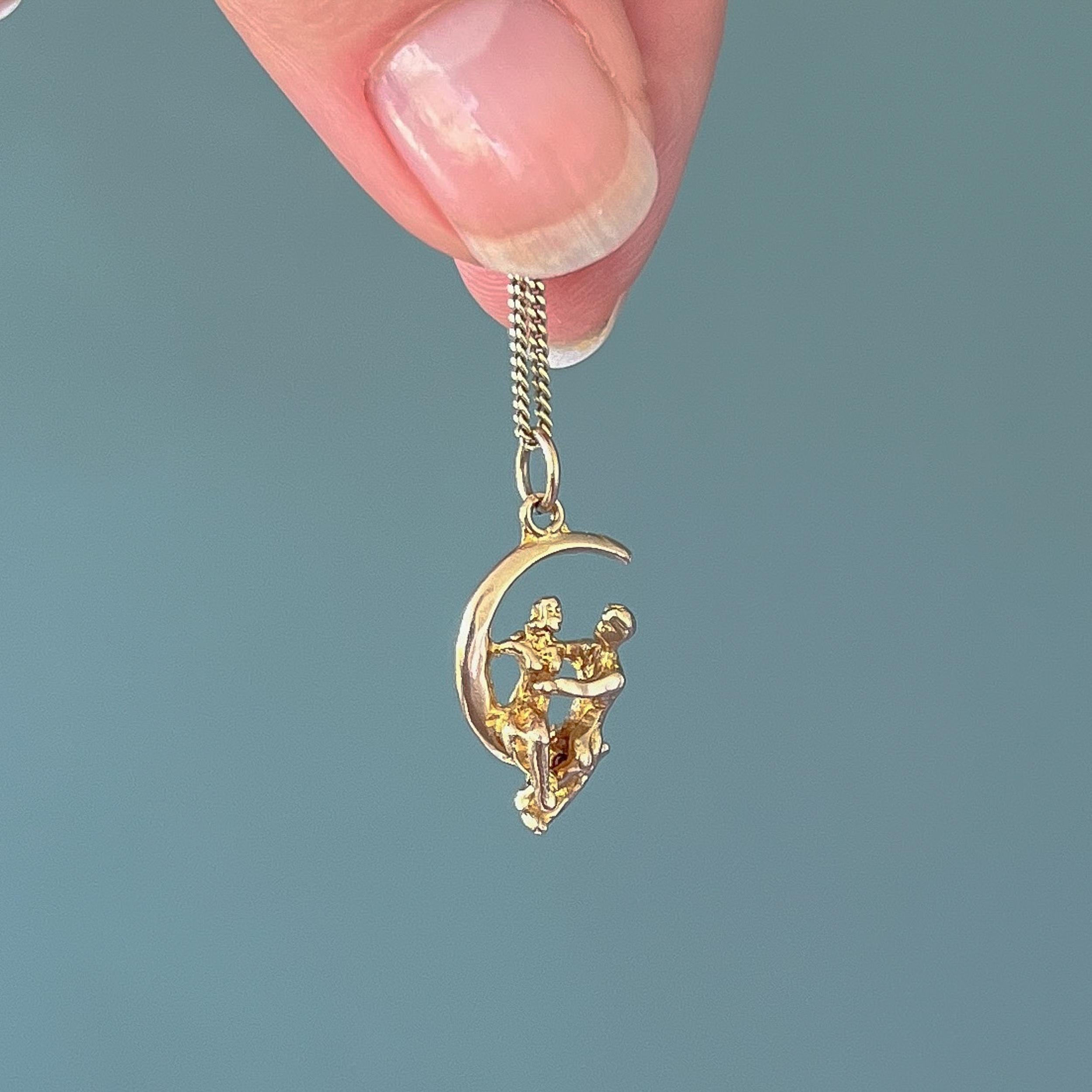 This is a vintage 9 karat yellow gold loving couple on a crescent moon charm pendant. This charm is quite rare with this lovely love couple sitting on a this crescent moon, romantically in love with each other. The charm is movable, the man can lean
