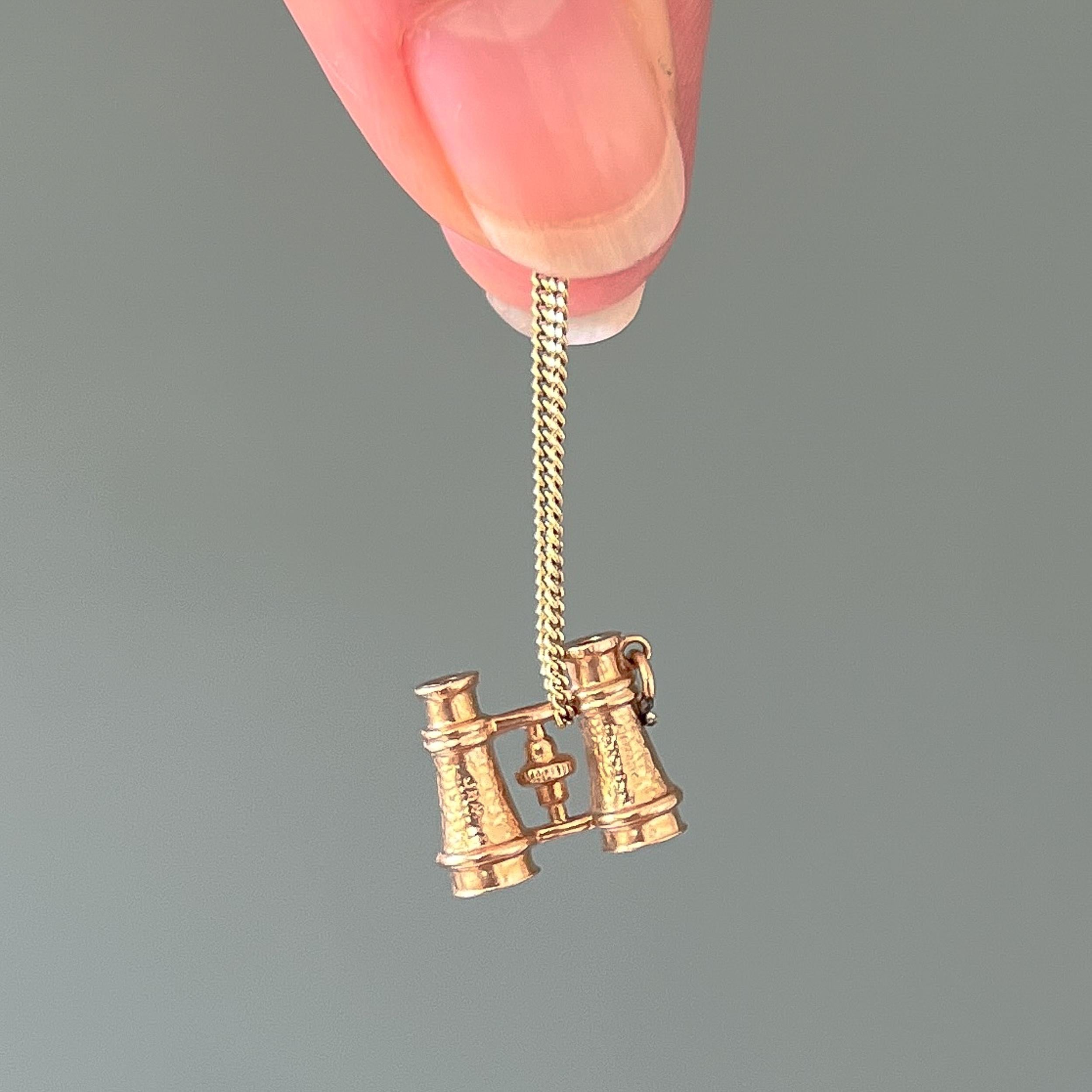 A vintage 9 karat yellow gold opera binoculars charm pendant. This miniature Galilean binoculars charm is usually used at performance events, whose name is derived from traditional use of binoculars at opera performances. It has nice details and