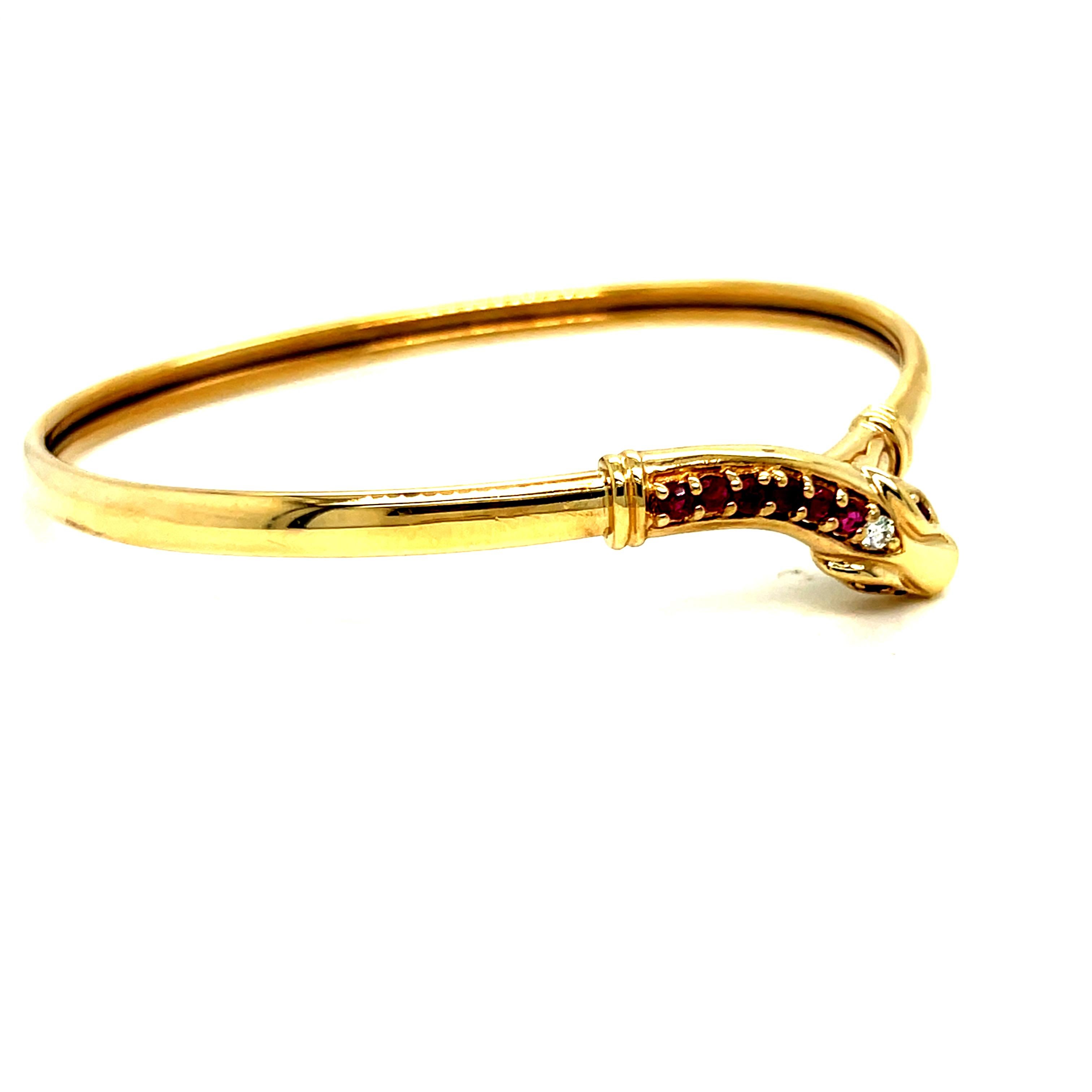 Diese Armspange aus 9 Karat Gelbgold schlängelt sich um das Handgelenk und lässt sich an ihrem eigenen Schwanz befestigen. Sie hat schöne runde Rubinaugen sowie Rubine und einen Diamanten am Kopf. Es gibt insgesamt 8 runde Naturrubine, insgesamt ca.