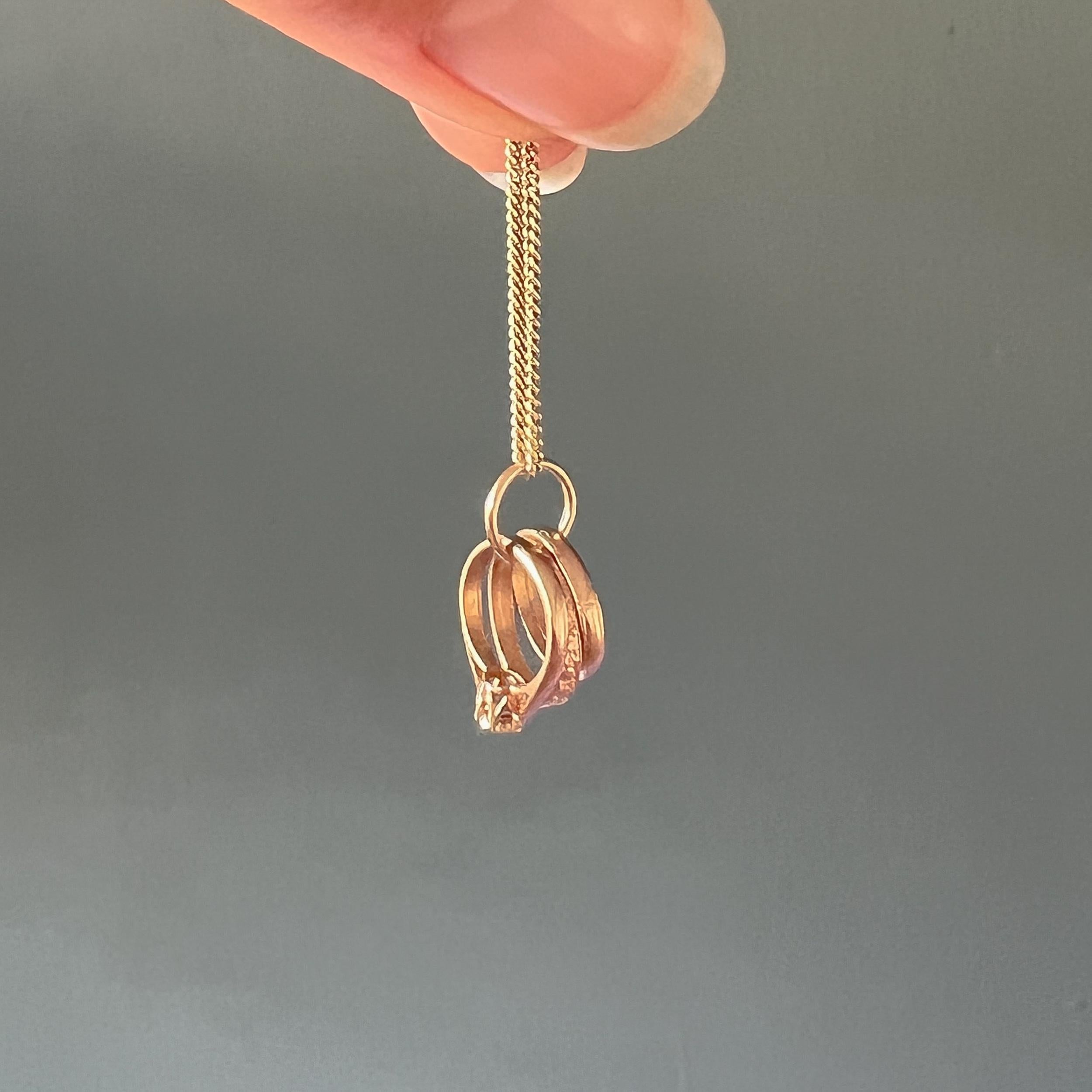 This is a vintage 9 karat yellow gold trinity rings charm pendant. This rings are nicely detailed and beautifully made with gold and yellow gold tones. The first ring has a clear stone which reminiscent of a diamond, the second ring is smooth