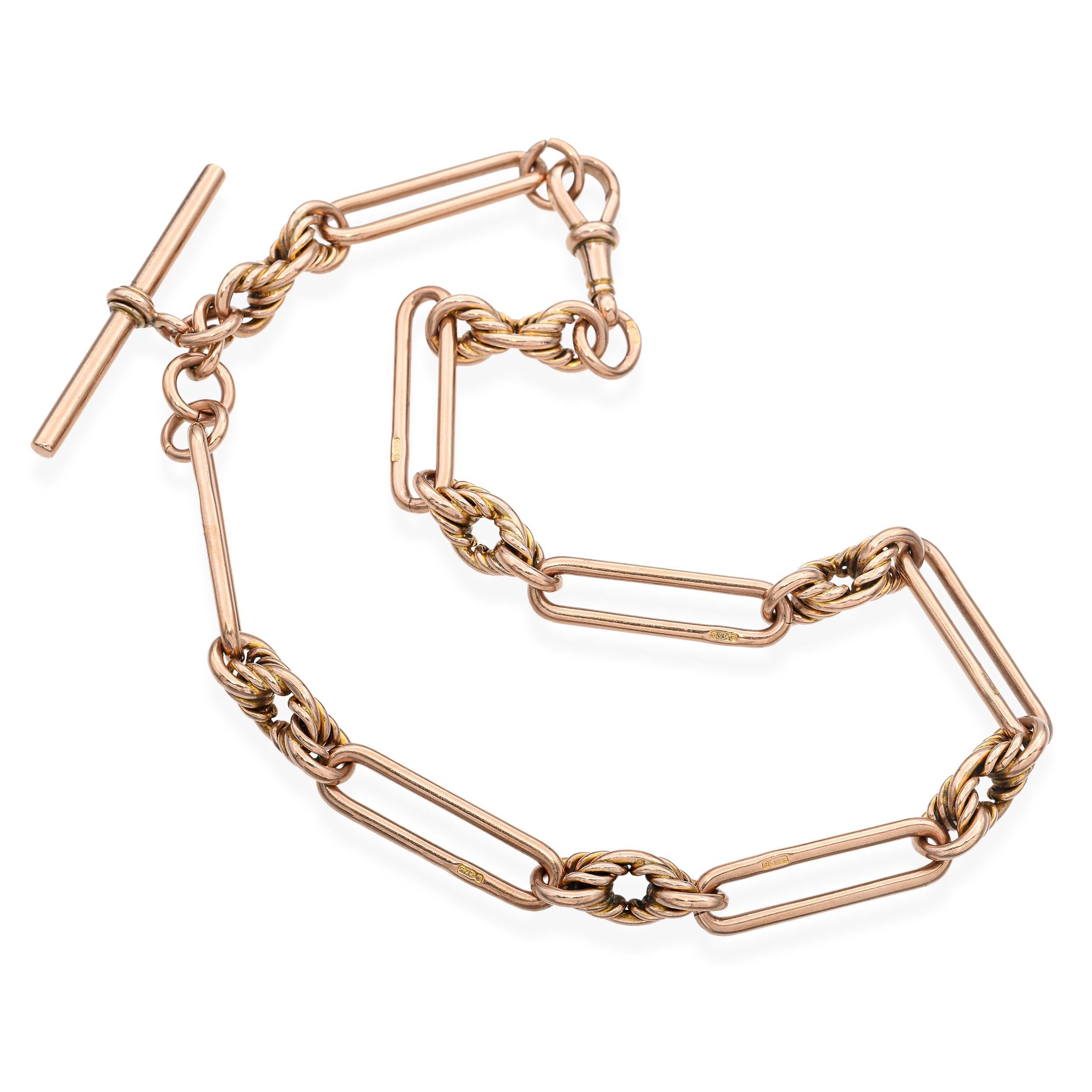Esta clásica cadena de reloj de bolsillo vintage está fabricada en oro rosa de 9 quilates de tonos cálidos, ofreciendo una refinada mezcla de utilidad y elegancia. El diseño presenta una sólida barra en T, que tradicionalmente se lleva a través del