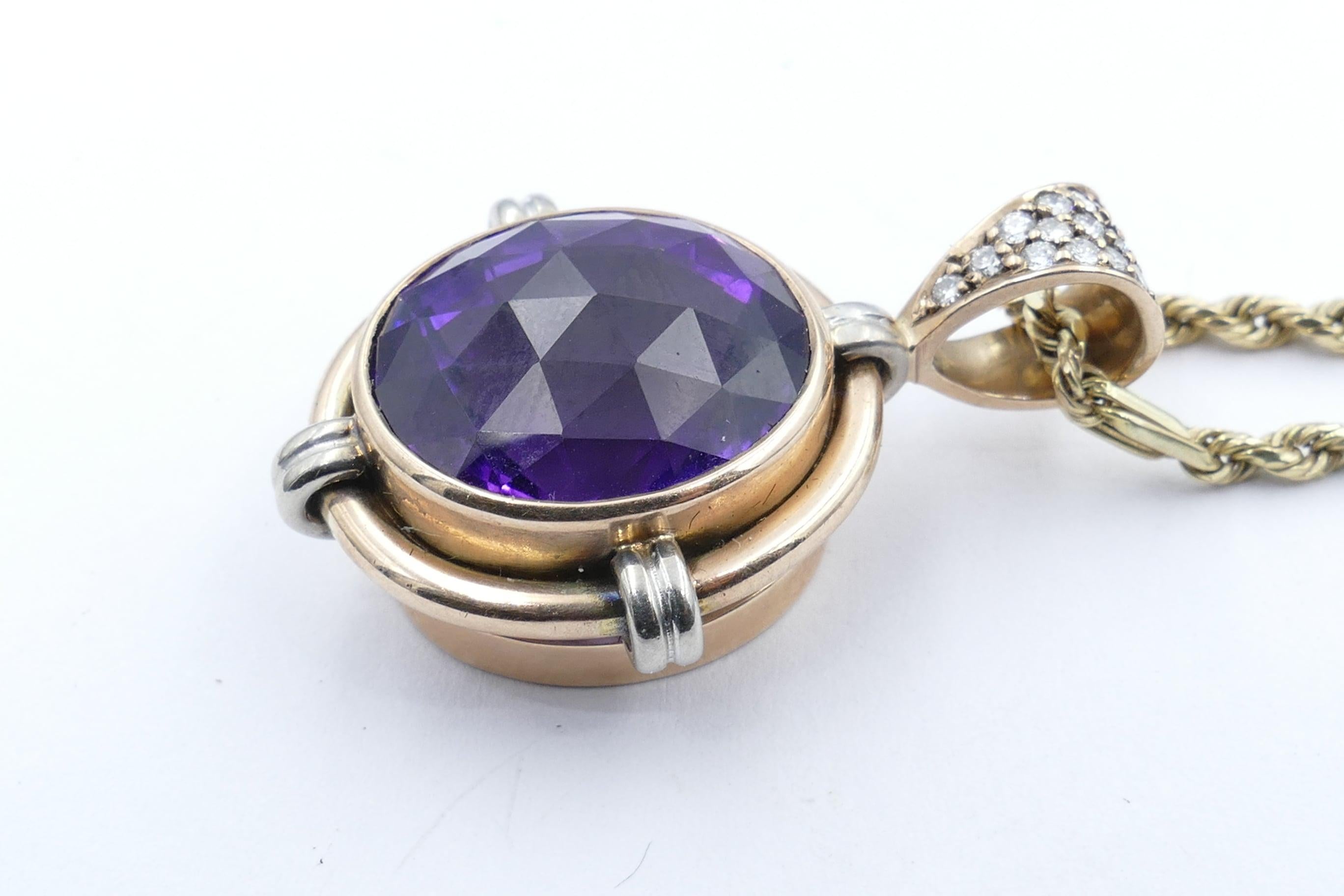 A large deep vivid purple Amethyst is the centrepiece of this beautifully crafted pendant with a Diamond Bail. 
The Stone is 24.01 carats, clarity eye-clean, oval cut, bezel set.
As well there are 13 round brilliant cut Diamonds, Colour G/H, Clarity