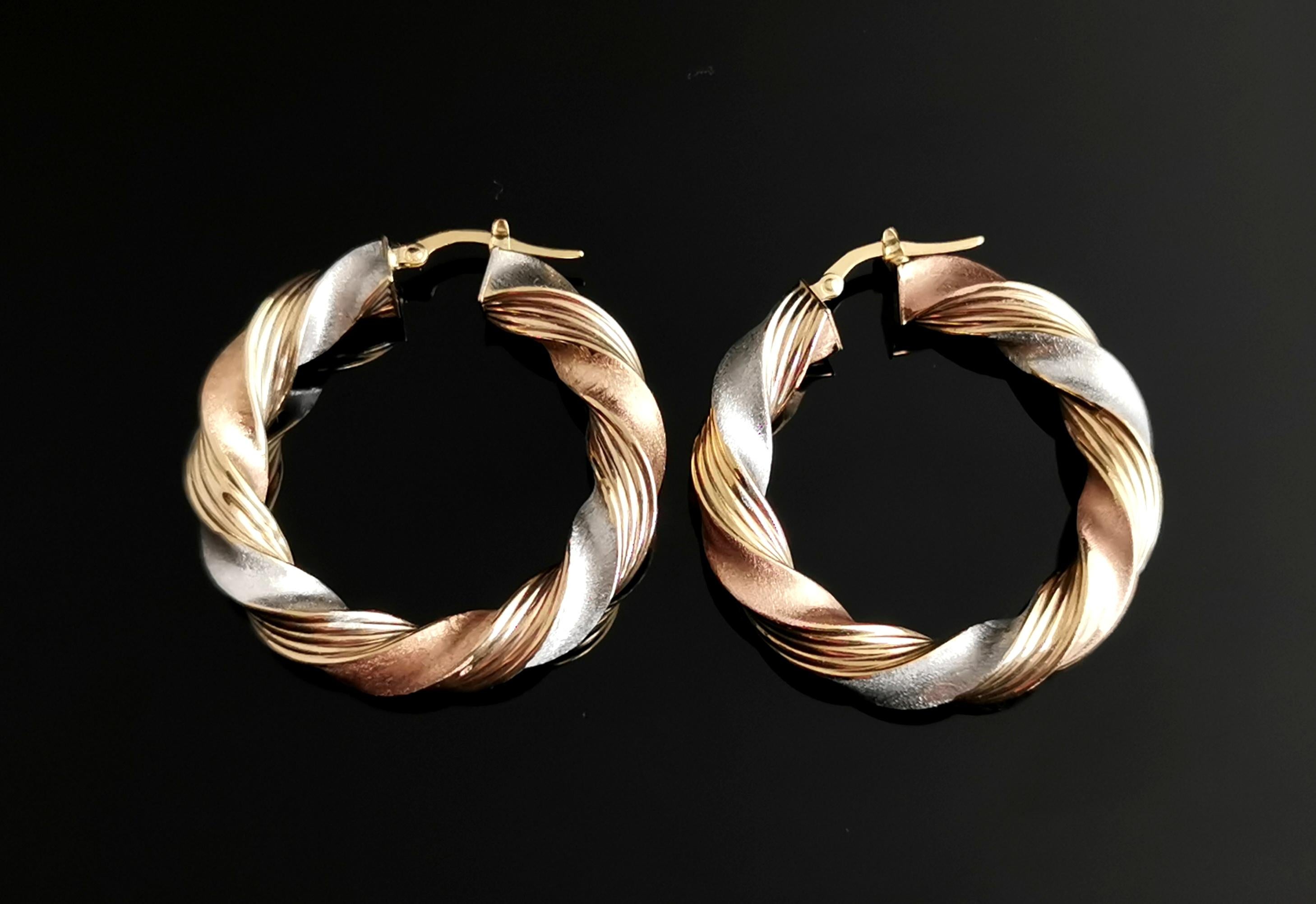 A gorgeous pair of vintage tri colour or three colour gold earrings.

These are crafted in 9k white, rose and yellow gold with each colour neatly interwoven with the other.

Medium / large sized hoops with a beautiful twist design and a lightly