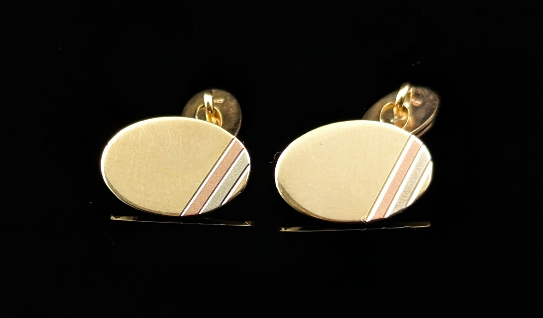 A Very attractive pair of Vintage 9ct gold cufflinks.

Oval shape cufflinks with a stylish engraved corner design with a tri colour gold banding of rose, white and yellow gold, the majority of the oval being a rich high polished yellow gold.

They