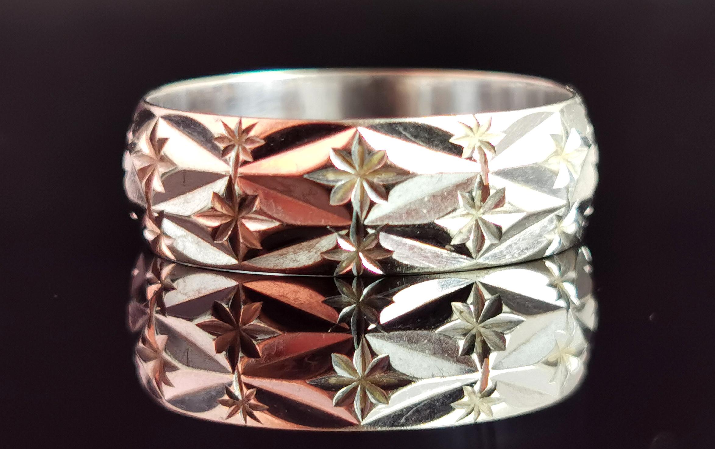 A gorgeous vintage 1970s 9kt white gold star motif band ring.

A lovely chunky white gold band with an all over geometric diamond pattern engraved with stars.

The interesting pattern and shape along with the stars really transform this ring from