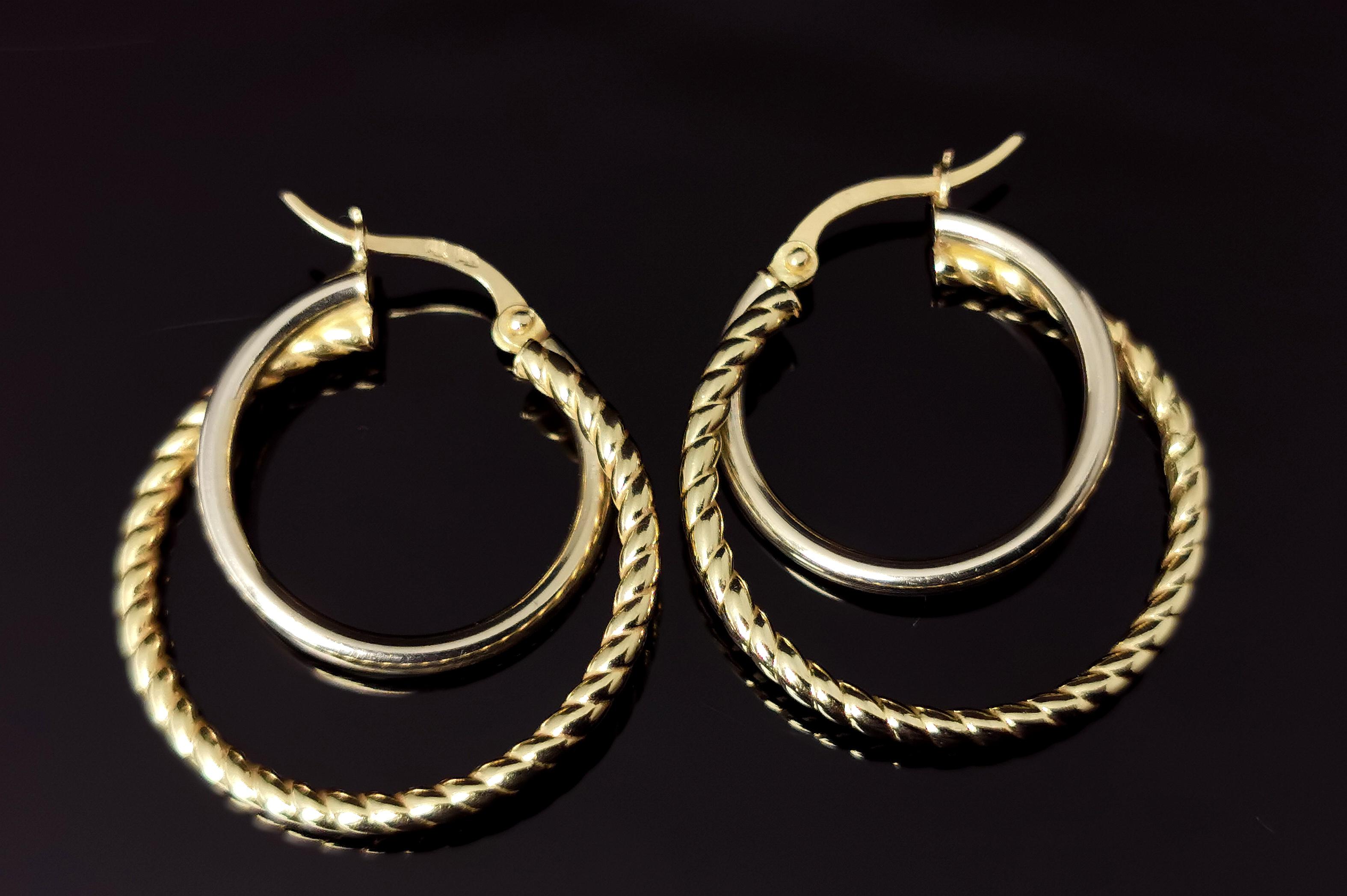 A gorgeous pair of vintage hoop 'double' hoop earrings.

These are crafted in 9ct yellow gold.

Medium sized hoops with a beautiful design, the larger twist hoop to the outside and a smaller plain interlocking hoop within this.

They are hollow so