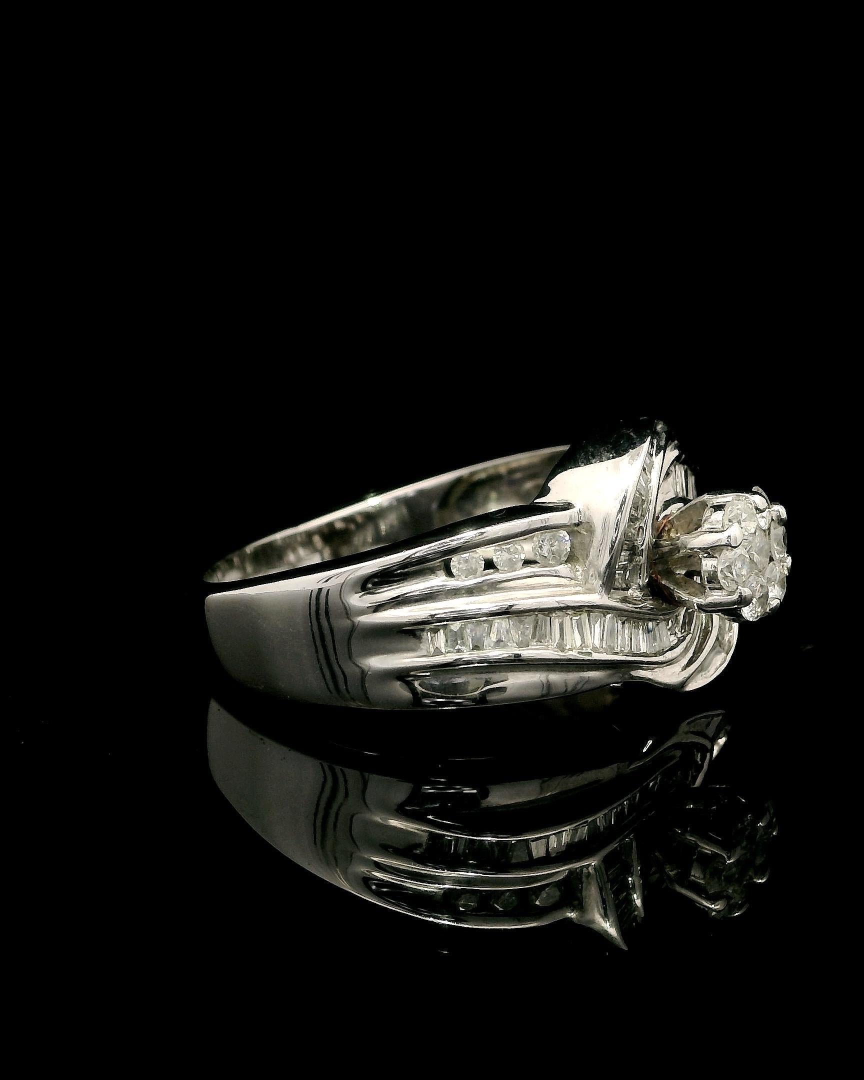 Anello con diamanti d'epoca in oro 9kt - circa 1,00 carati di diamanti rotondi e taglio baguette
Questo anello con diamante in oro 9 carati è uno splendido pezzo di artigianato d'epoca, che mette in mostra un'eleganza senza tempo con uno scintillio