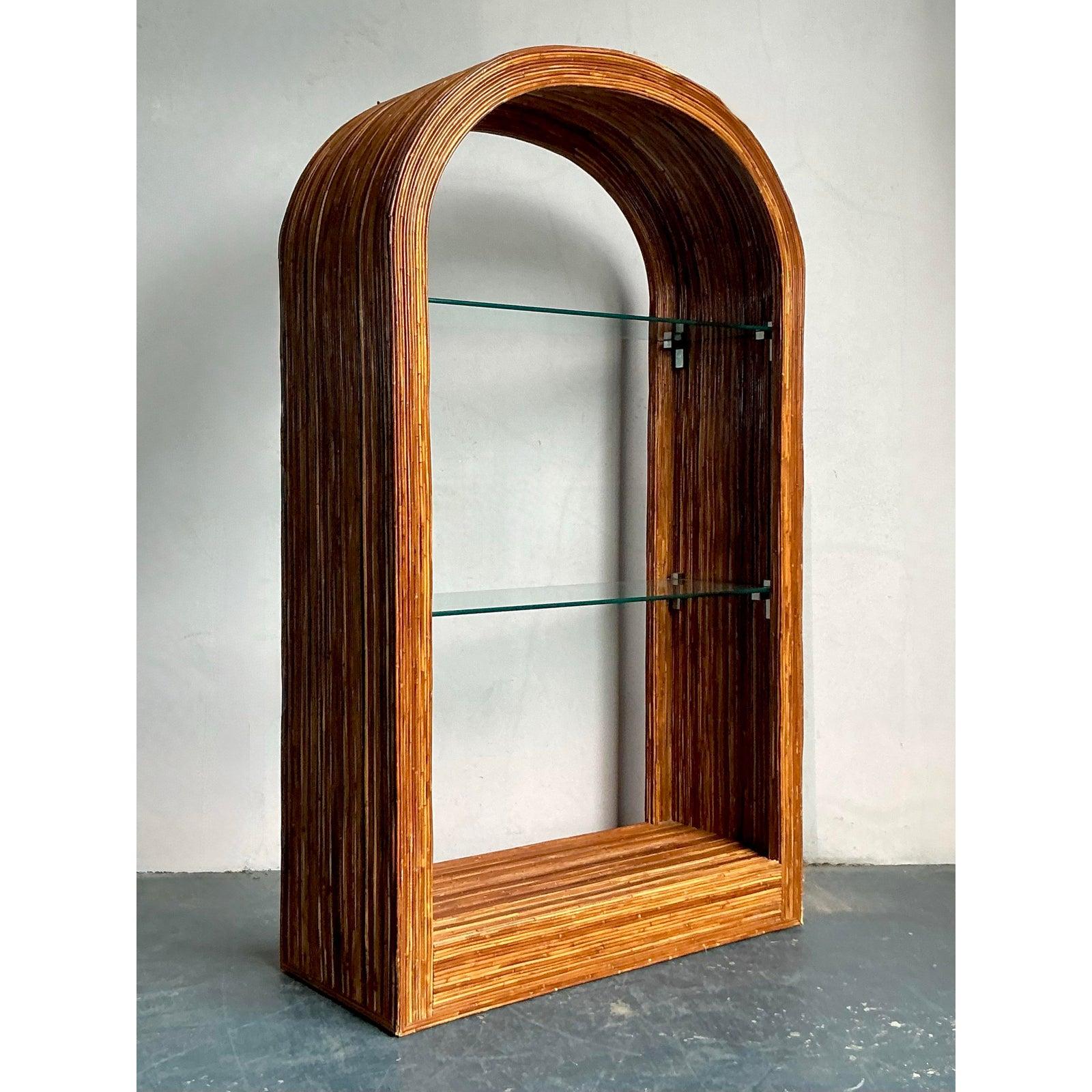 Diese spektakuläre Etagere ist ein Beweis für die innovative Struktur des tropischen modernen Designs der Mitte des Jahrhunderts. Der fast zwei Meter hohe Schrank hat einen prächtigen, gewölbten Rahmen, der aus Tausenden von eng gebündelten