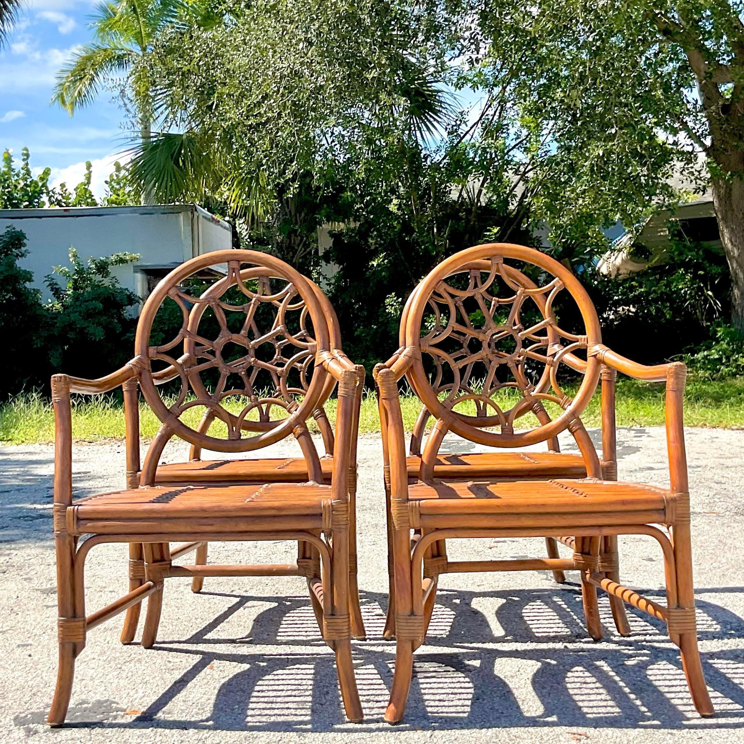 A stunning set of four vintage Coastal dining chairs. Done in the manner of the McGuire group. Beautiful rattan frame with a chic web back design. Acquired from a Palm Beach estate. 