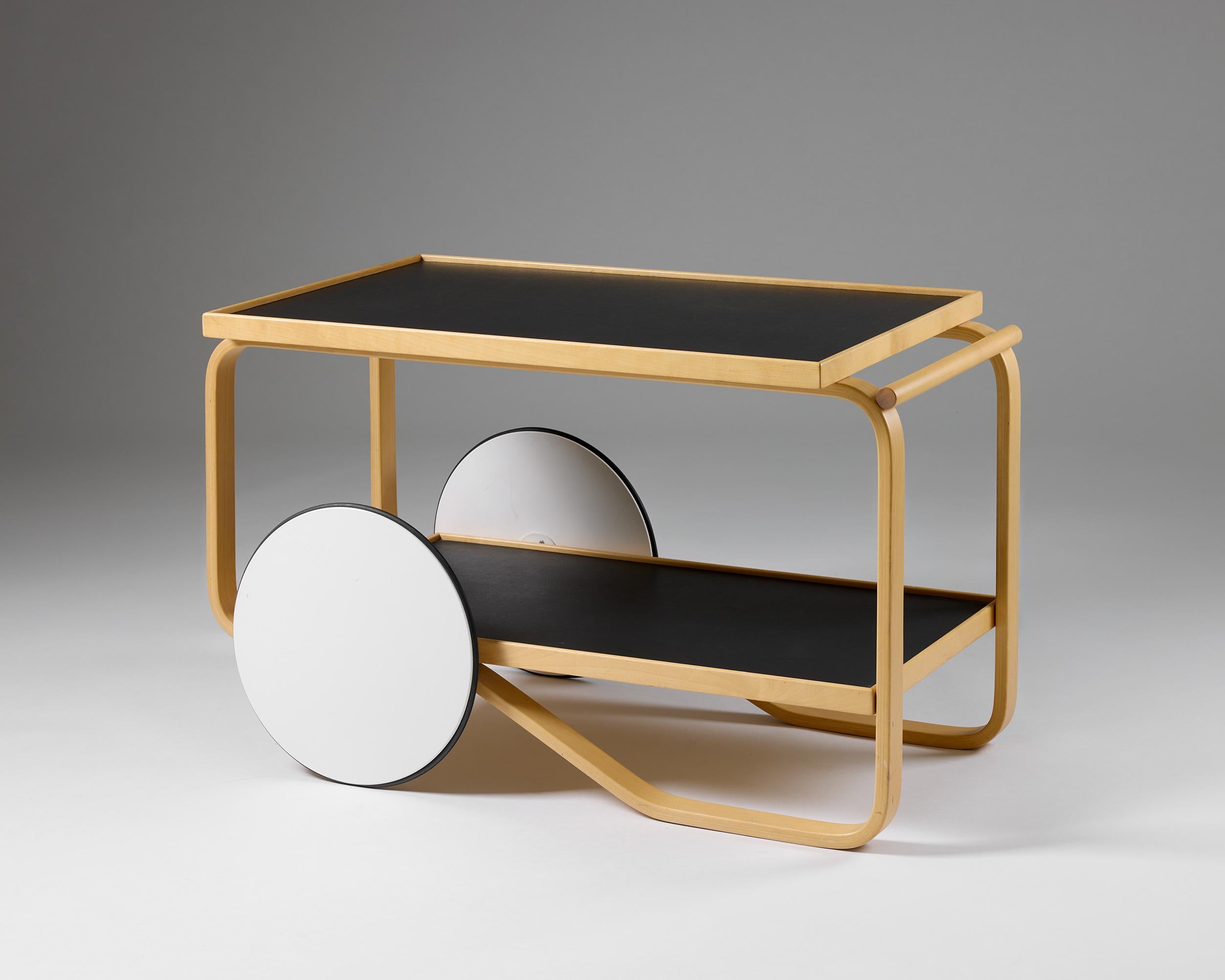 Alvar Aalto diseñó el carrito de té 901 en 1936, durante un periodo muy productivo que incluyó su trabajo arquitectónico para el Pabellón de Finlandia en la Exposición Universal de París de 1937. El carrito refleja su interés más amplio por crear un