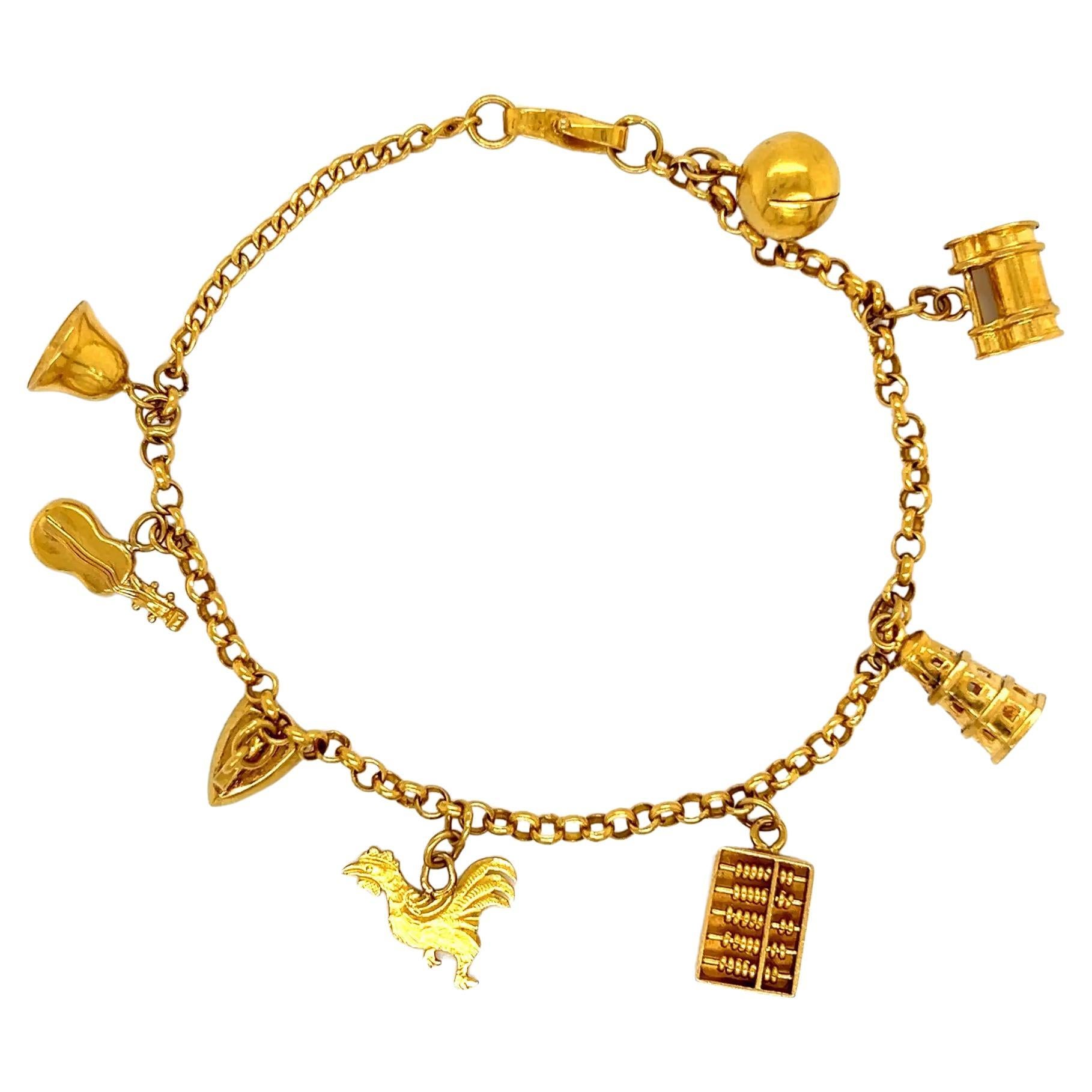 Bracelet vintage avec boulier, cloche, Cello, fer et coq en or en vente