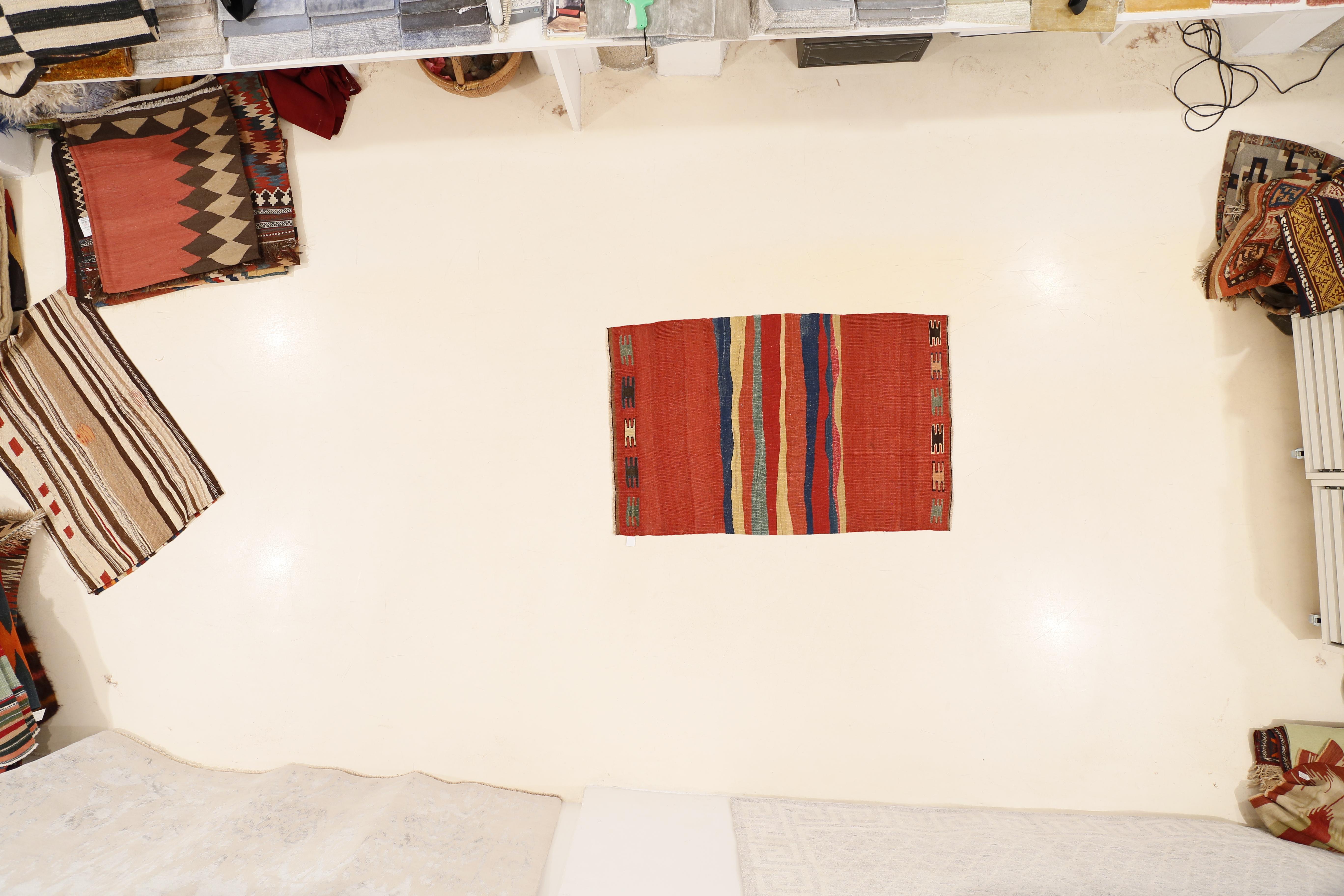 A graphic Kurdish flat-weave characterized by a central cluster of horizontal stripes similar to paint brushstrokes across a rich red open field background. The abstract modernity of certain types of tribal rugs are an indication of the ancestry