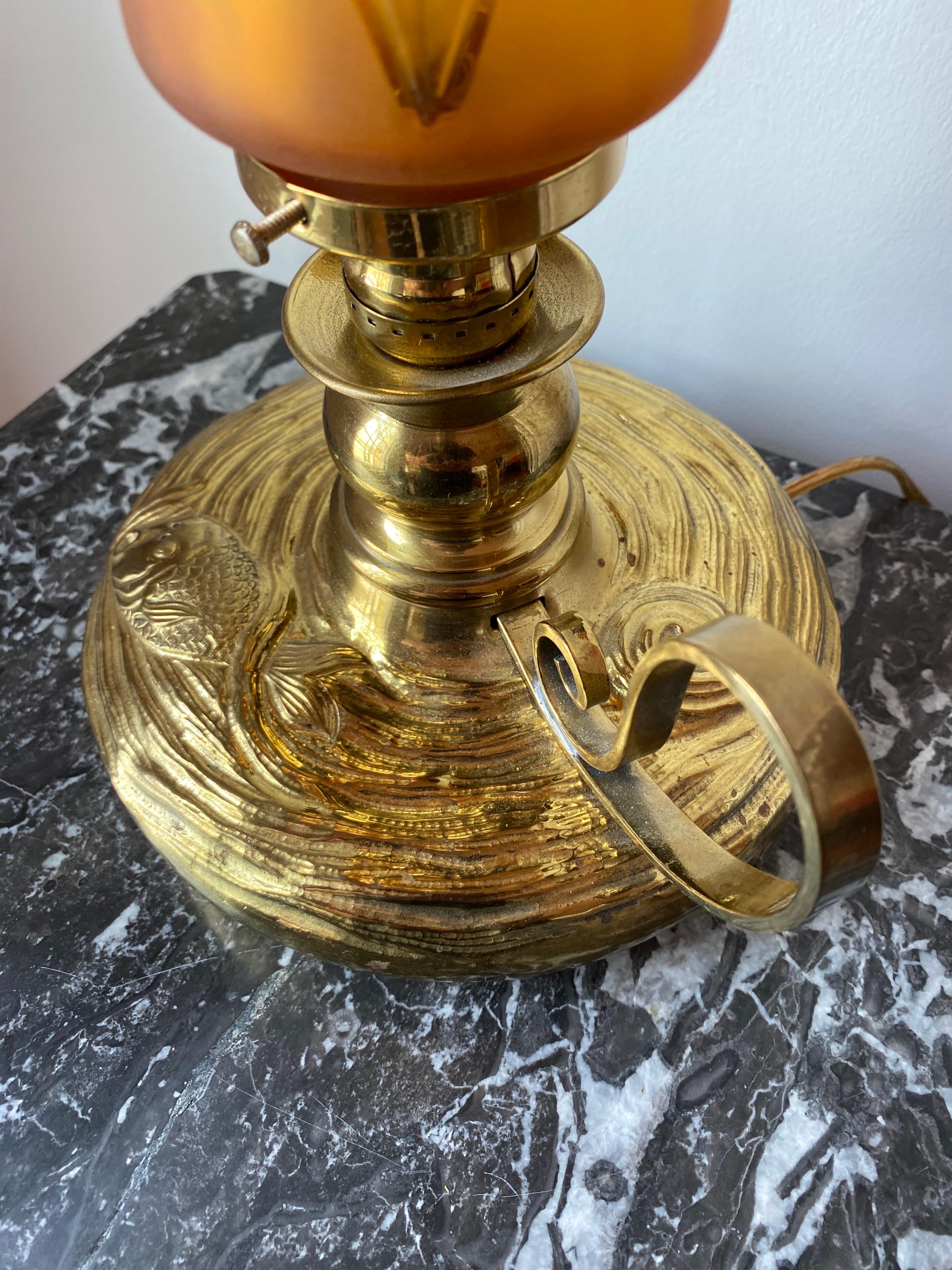 Schönes Beleuchtungsstück im Stil einer Öllampe mit Glasschirm.  Dieses Stück ist romantisch und liebenswert.  Der Sockel der Leuchte ist gefilzt und hat eine Messingkonstruktion, die mit einem Koi im Teich gestaltet ist.  Die Linien und Figuren
