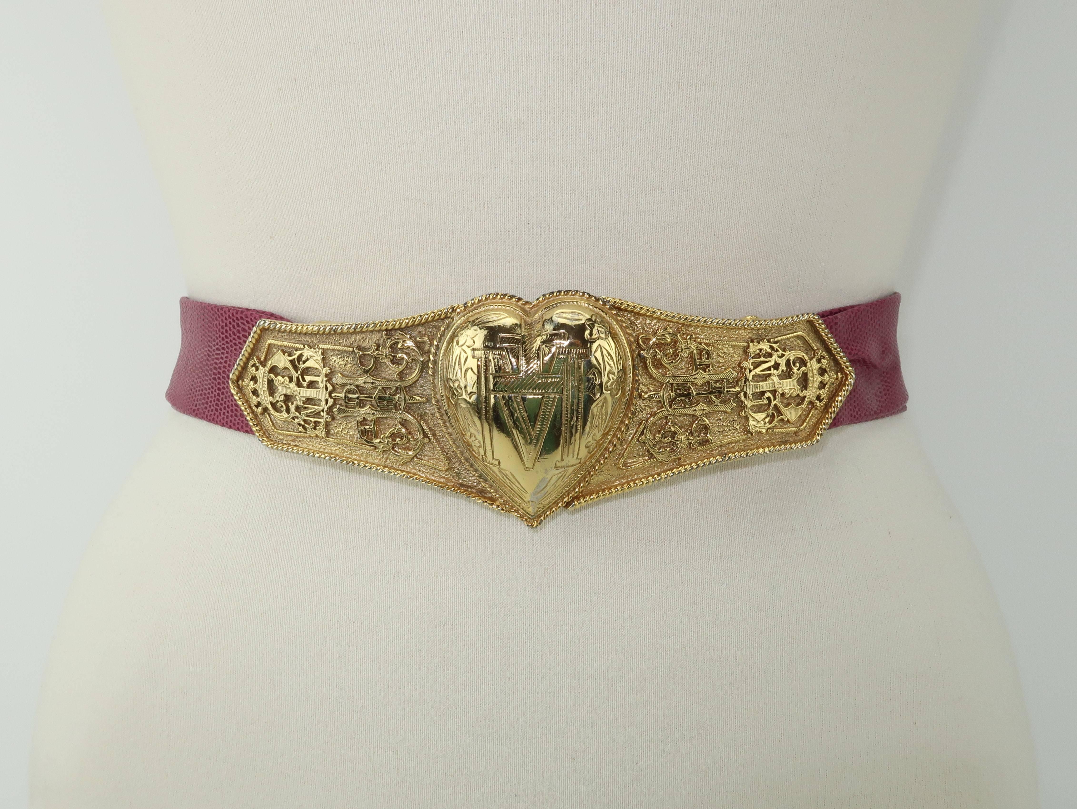 Exceptional!  This C.1980 Accessocraft NYC belt buckle depicts a heart flanked by medieval style symbols including a reference to the French heroine, Joan of Arc, and the French village, Chaudes-Aigues.  Whatever the meaning, the gold tone metal
