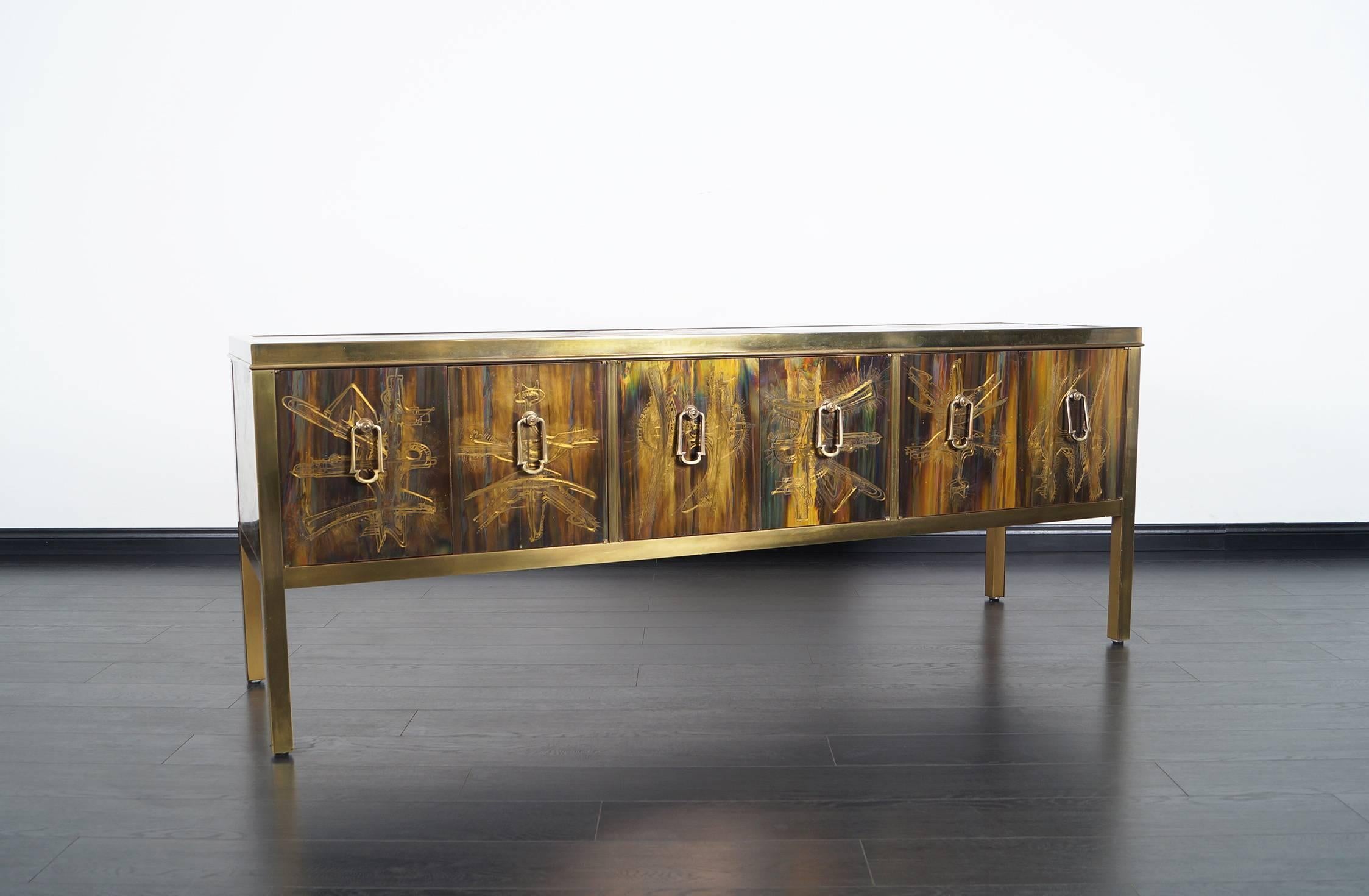 This stunning acid etched credenza by Mastercraft, with aced etched panels by Bernhard Rohne for Mastercraft. Features a unique acid etched design and solid brass pulls that are used to open six doors that reveal storage space.