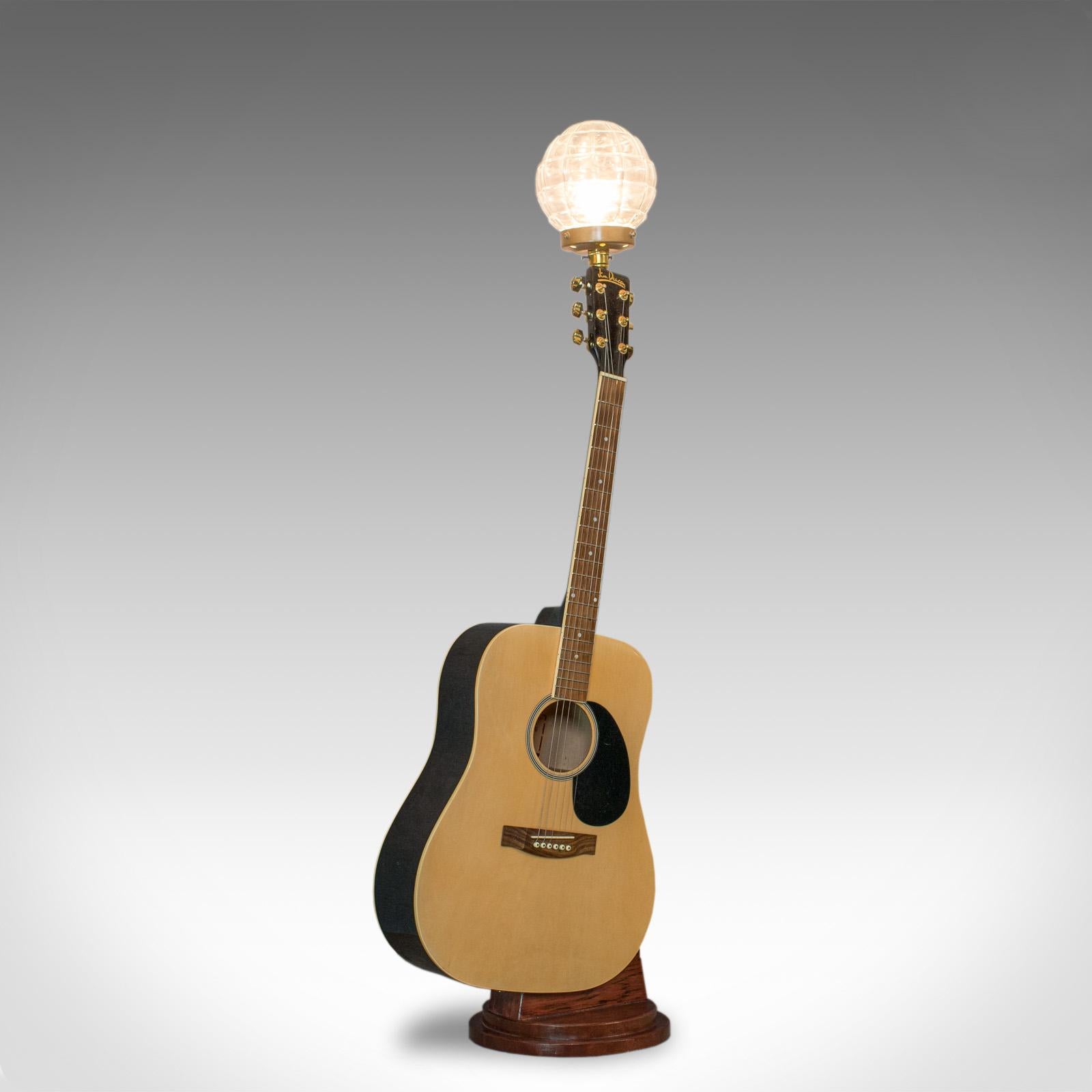 This is a vintage acoustic guitar lamp. An English, bespoke handcrafted table light with a Jim Deacon guitar body and a glass dome light fitting.

In excellent condition, fully working with quality, glass dome lamp
Classic Dreadnought acoustic