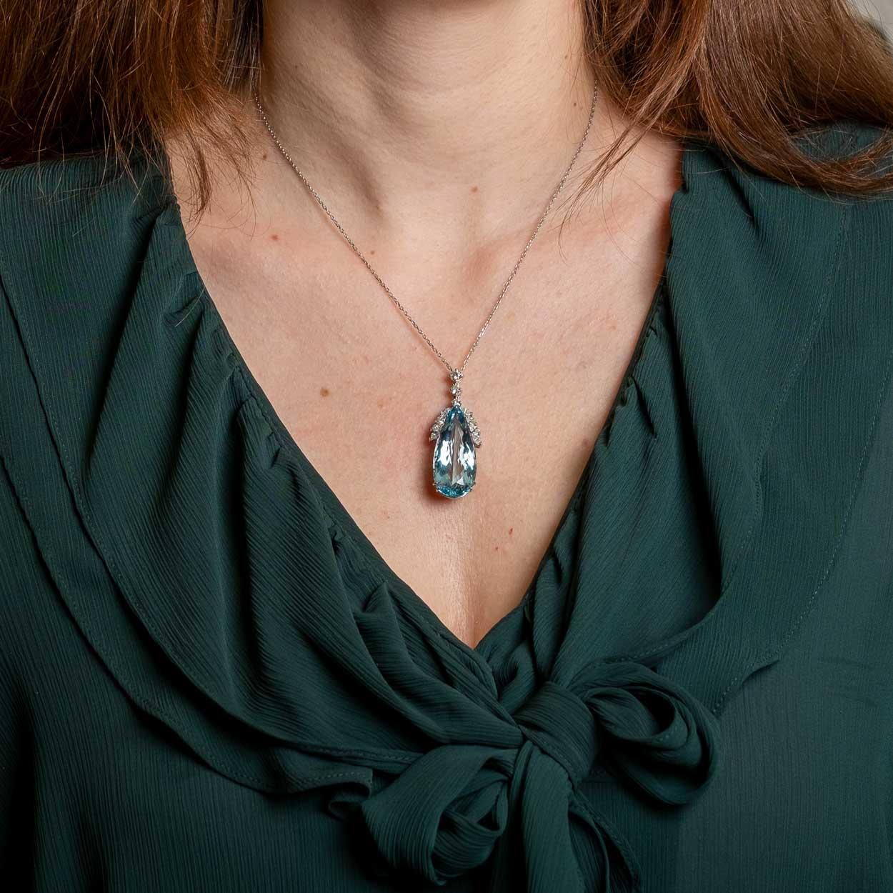 Splendido ciondolo d'epoca in oro bianco 18 ct. con acquamarina naturale a forma di goccia luminosa di buon colore intenso di circa 26,60 ct. Evidenziato da diamanti naturali a taglio rotondo di circa 1,30 ct in totale.

Punti salienti:
- Montatura