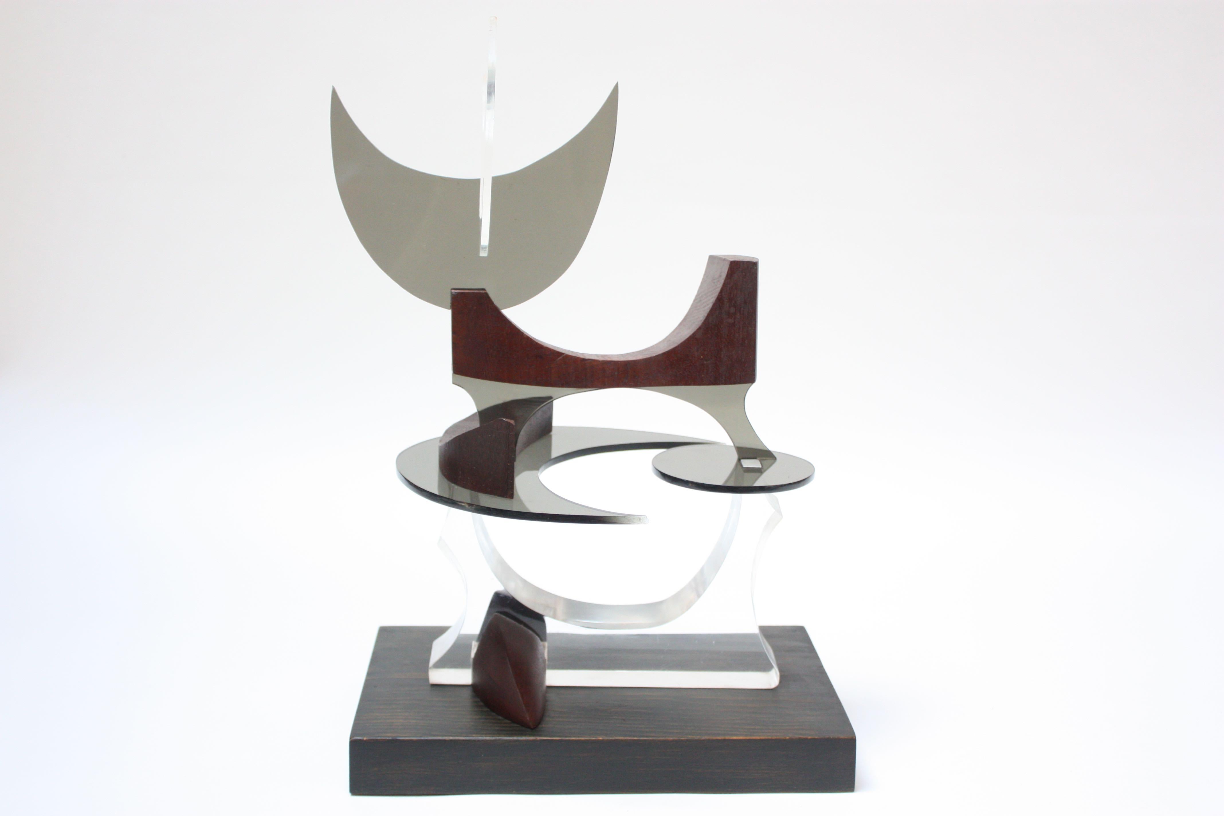 Robert D. A. B. (nato nel 1927-2015 - Marshfield, MA, USA) scultura astratta composta da acrilico tagliato / lucite (sia fumé che trasparente) e noce scolpito assemblato per rappresentare un gatto. Montata su una tavola di pino ebanizzato, circa