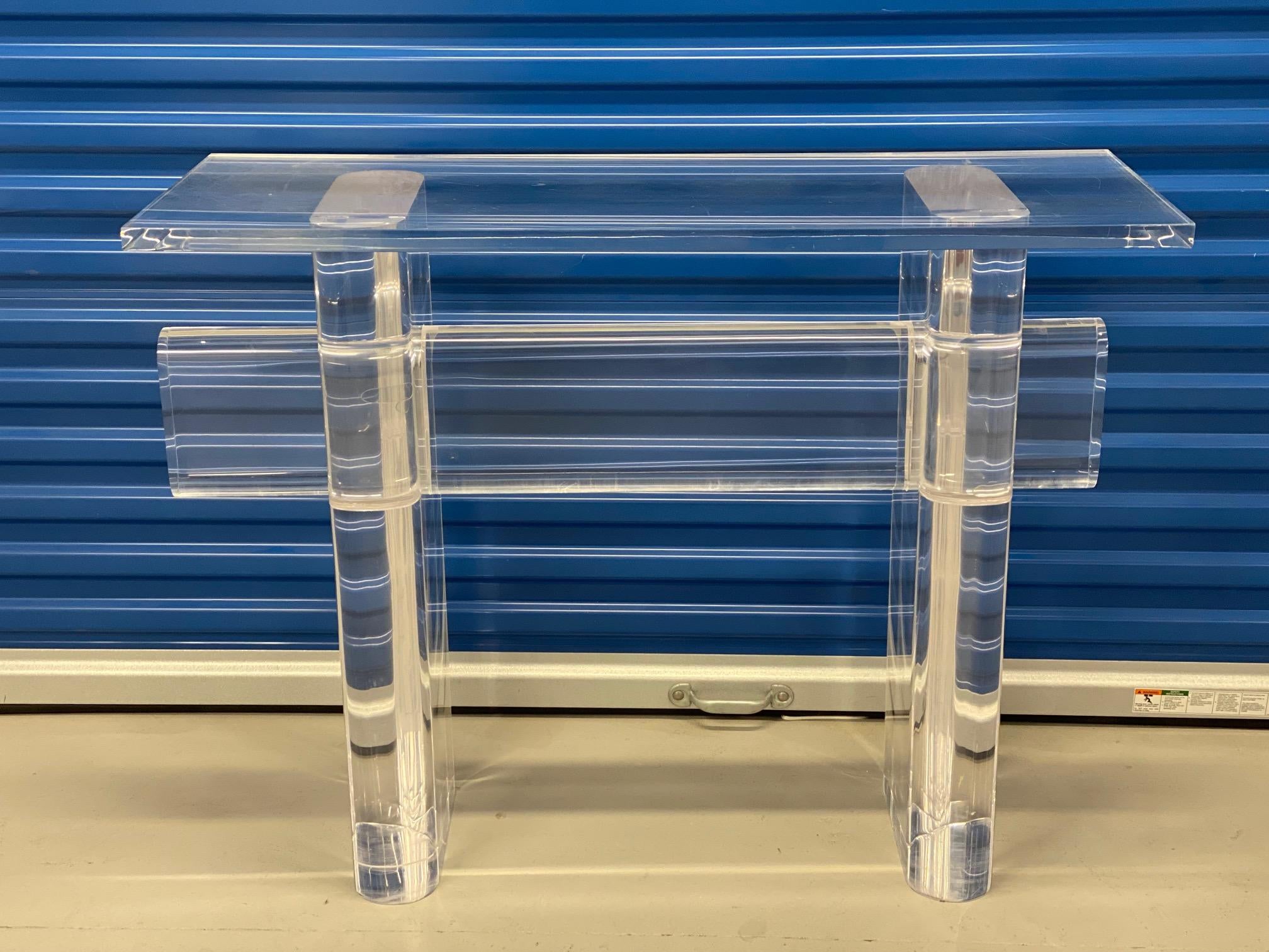 Mesa consola acrílica vintage, Siglo XX
Se trata de una consola del siglo XX fabricada íntegramente en acrílico transparente. Presenta una encimera rectangular sostenida por dos gruesas patas cilíndricas unidas por un bastidor horizontal.  Las patas
