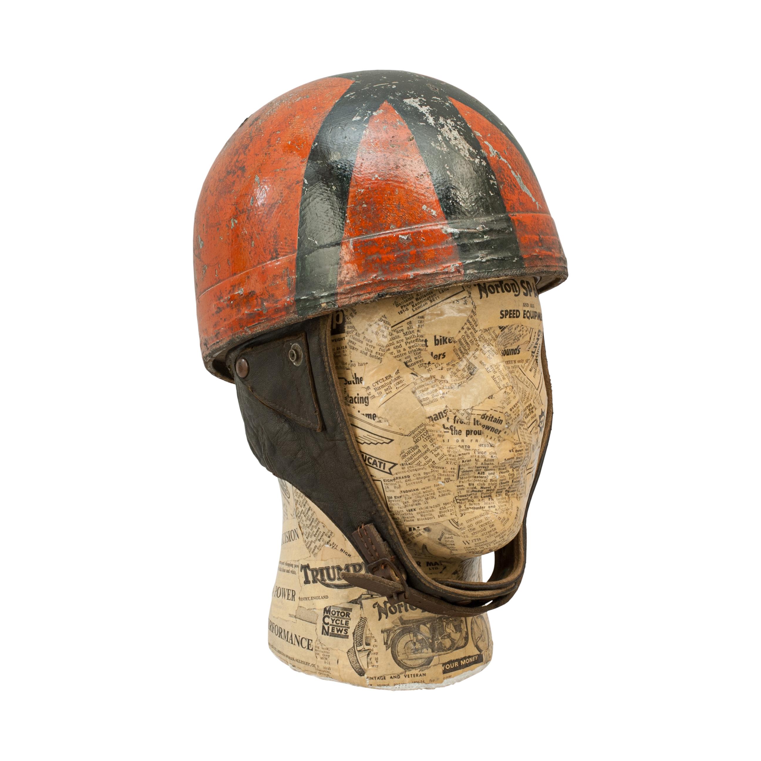 Vintage Cromwell motorcycling racing crash helmet.
A red and black motorcycle, pudding basin shape helmet made in England by Cromwell. This helmet has a cork interior, fitted with a leather headband and cloth straps keeping a space between the head