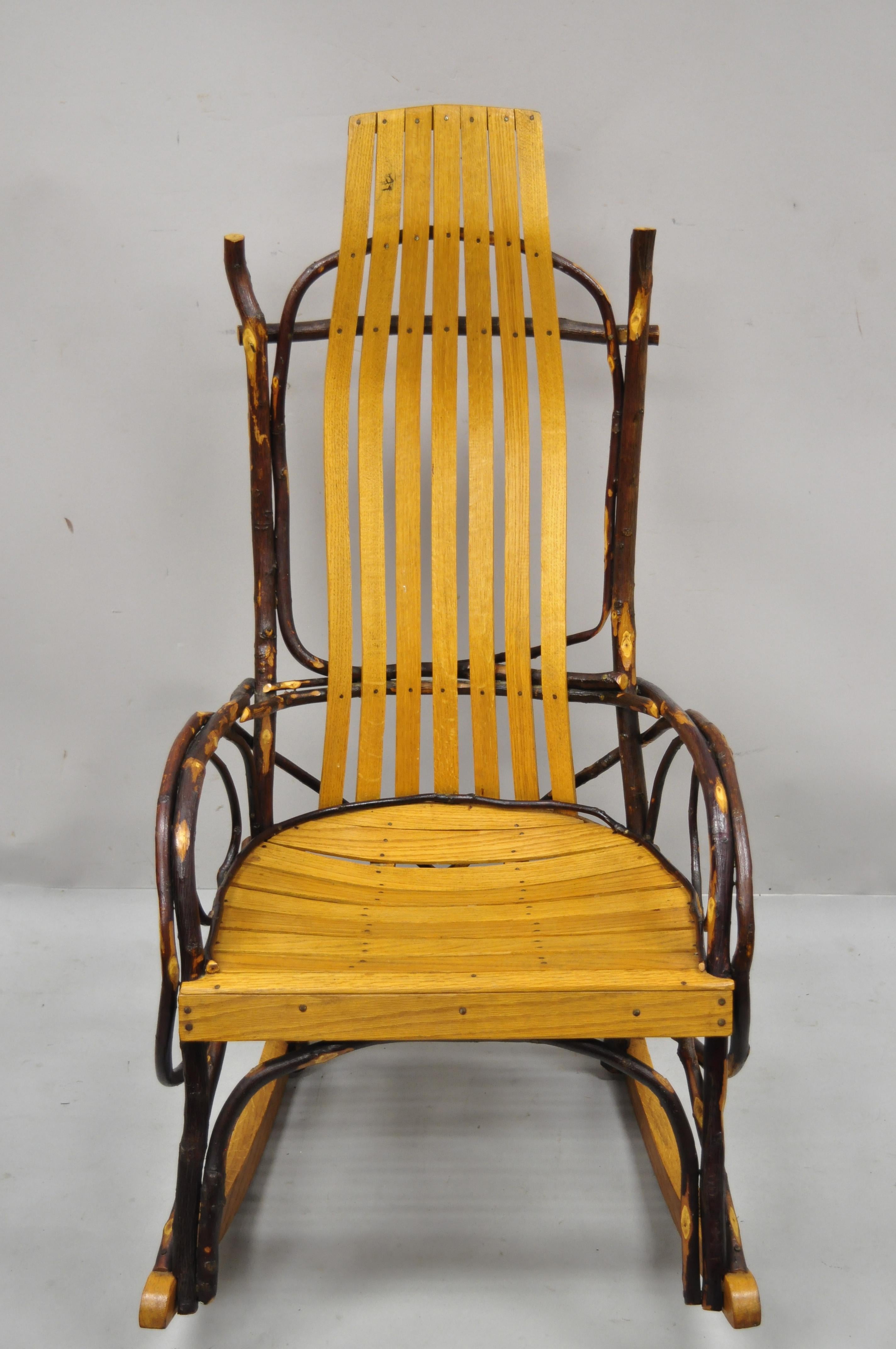 Vintage Adirondack tree branch twig Arts & Crafts primitive rocker rocking chair. Item features handmade tree branch form, wood slats, very nice vintage item, quality American craftsmanship, great style and form. Circa mid 20th century.