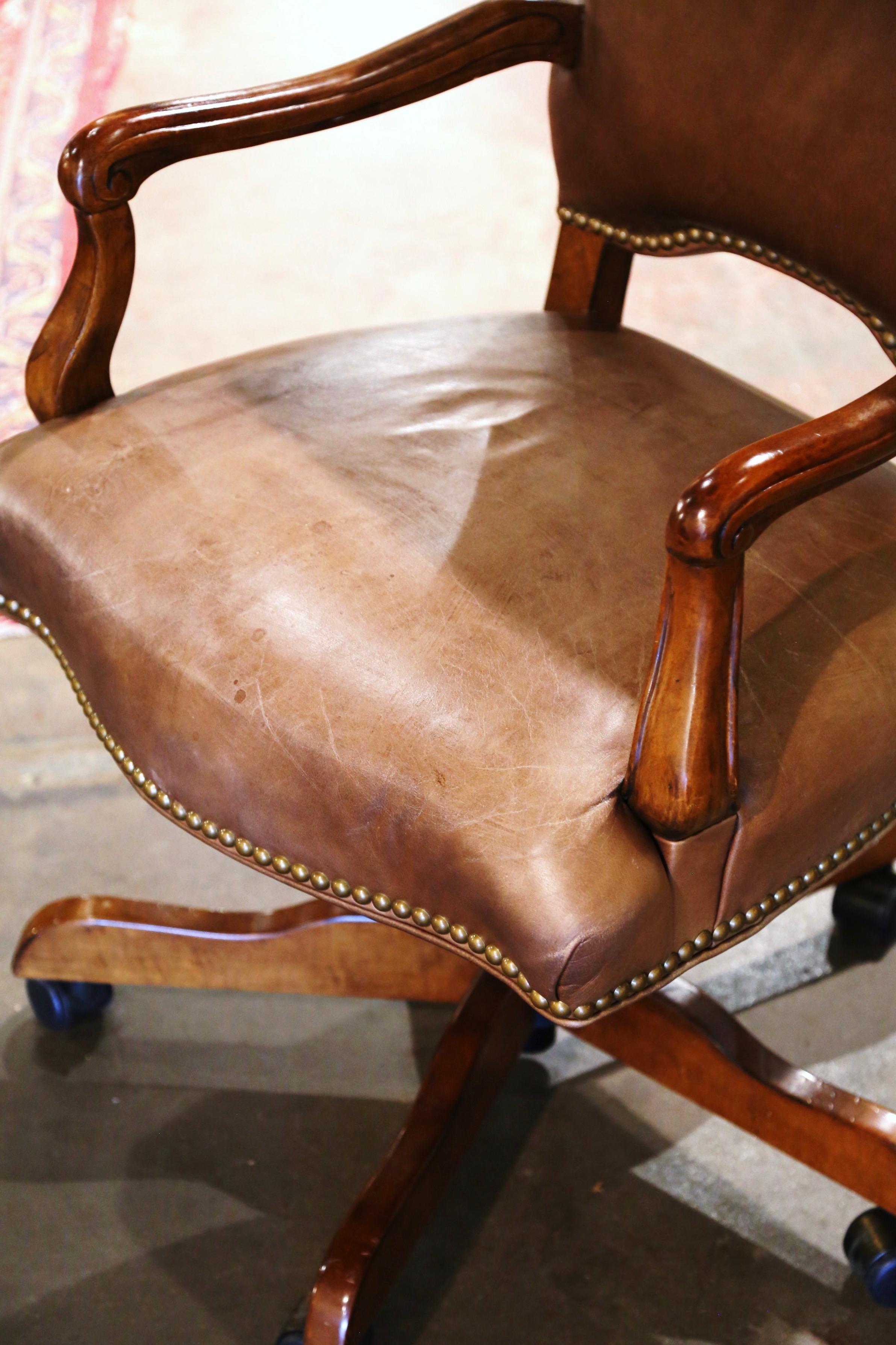 Habillez le bureau ou l'étude d'un homme avec cet élégant fauteuil vintage. Fabriquée à la main vers 1970 dans un style masculin, la chaise repose sur une base pivotante avec des pieds en bois se terminant par des roulettes en métal. Cette chaise