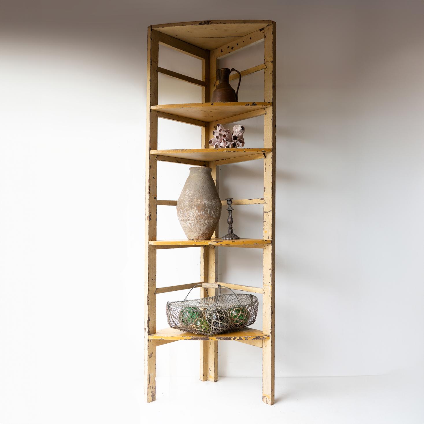 ADJUSTABLE CORNER SHELVING UNIT 
Seven removable triangular shelves (not including the fixed top) can be placed to suit the needs of the items you want to display. 

Originally from a German florist's shop.

In solid wood with original mustard