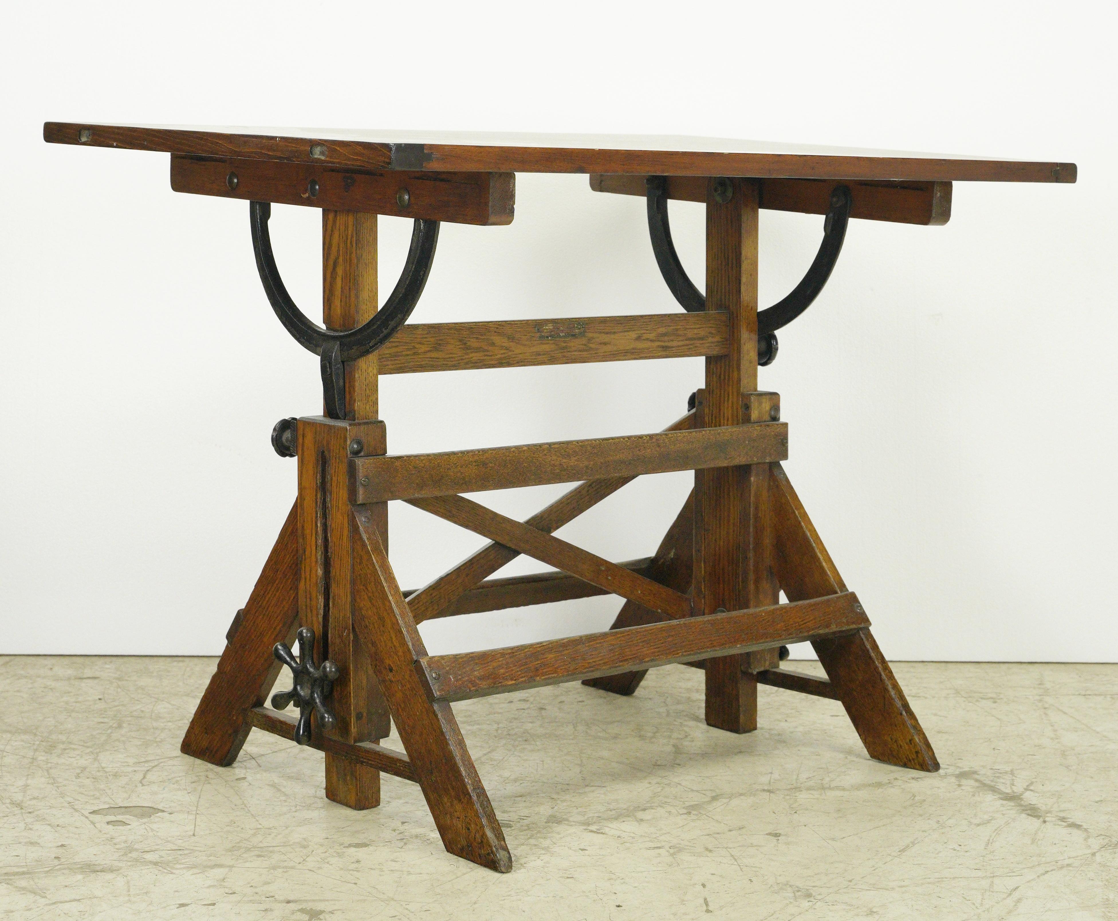 Antique dark stained drafting table made of oak and pine with black cast iron hardware. This piece was restored in our shop. Good condition with appropriate wear from age, with light scratches and minor dents. One available. Please note, this item