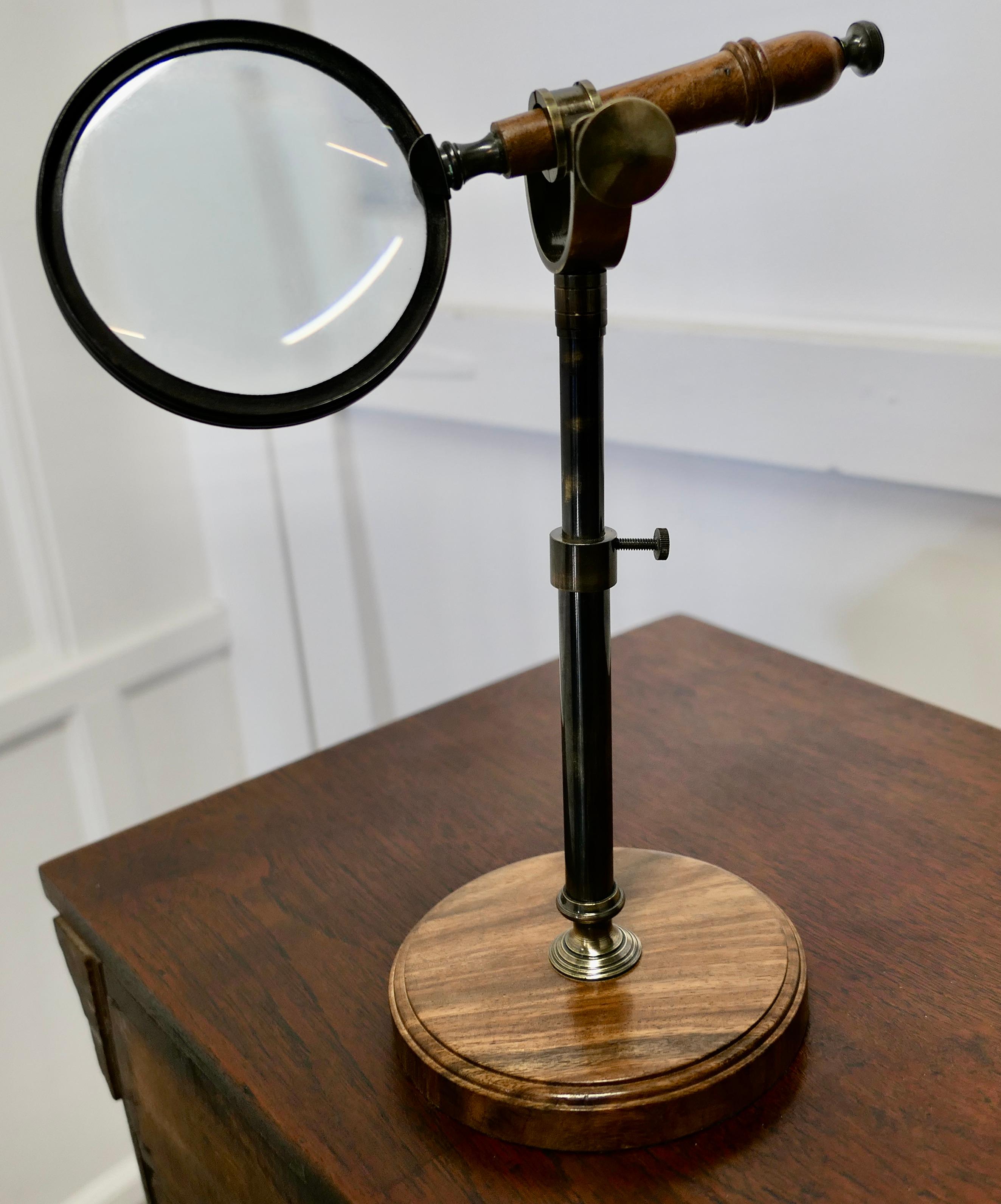 Vintage Adjustable Magnifying Glass on Stand

A very good quality magnifying glass, the glass stands on a turned walnut base, it has an adjustable height and tilt stem which holds it 
It has a turned wood handle and it is in good condition
The glass