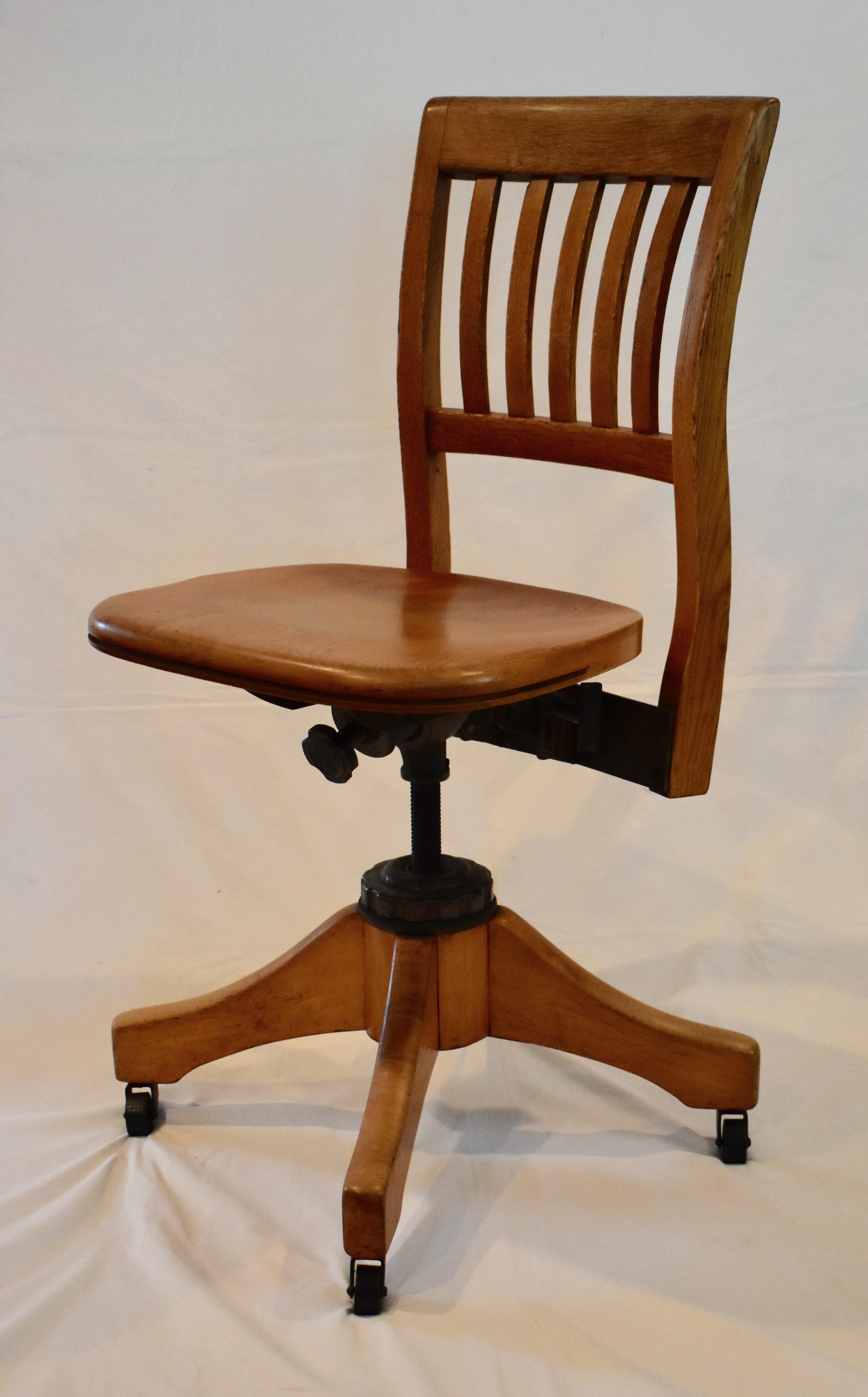 This is a handsome and graceful oak and maple adjustable office chair by the W.H.Gunlocke Company of Wayland, New York. Ergonomically designed, with attractive serpentine back stiles, the steel mechanism of this remarkable chair adjusts for height,