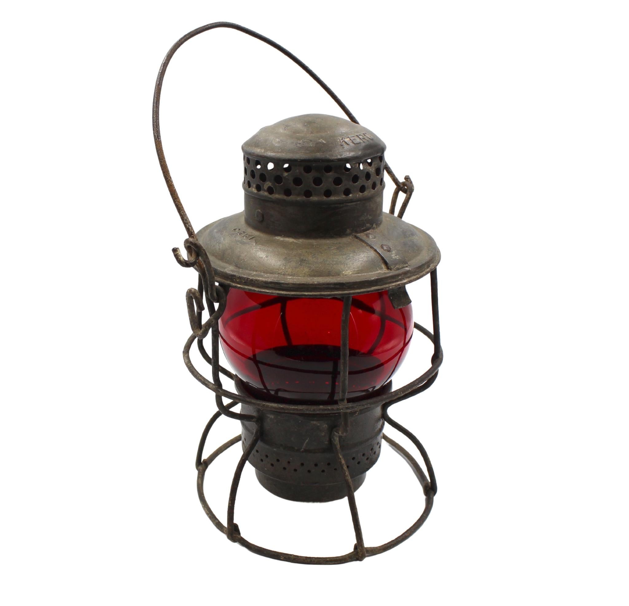 Presented is a vintage Adlake railroad kerosene lantern, with a red glass globe and wire caging. The lantern was manufactured by the Adams & Westlake Company of Chicago, Illinois, sometime between 1945-1965. It was originally used on the Chicago and