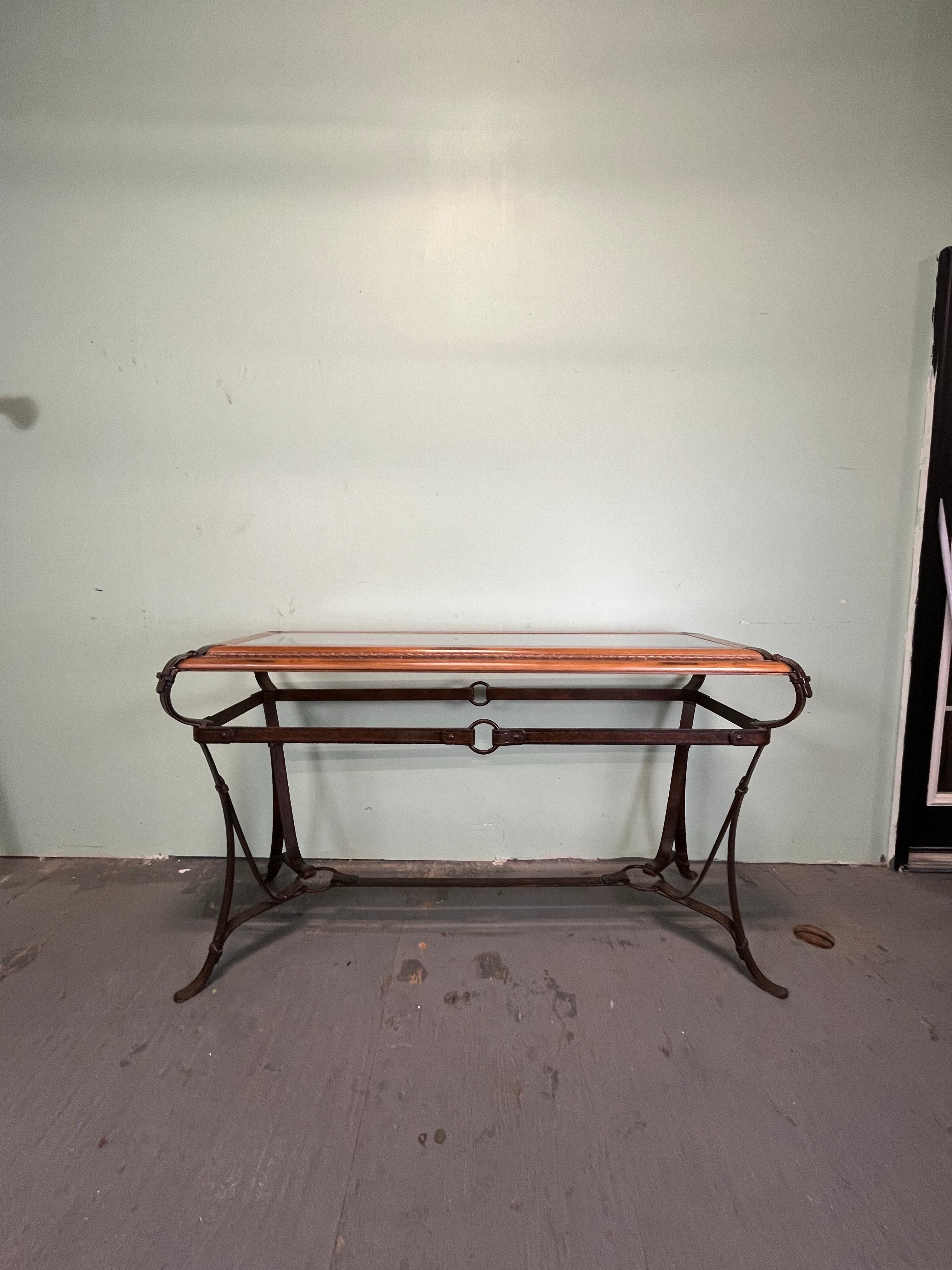 Schöne Konsole im Stil von Adnet, Hermes und Ralph Lauren. Sockel aus Eisen mit Kunstlederriemen, Tischplatte aus Holz mit geflochtenem Lederkeder und abgeschrägter Glasplatte. Sehr schwer. 